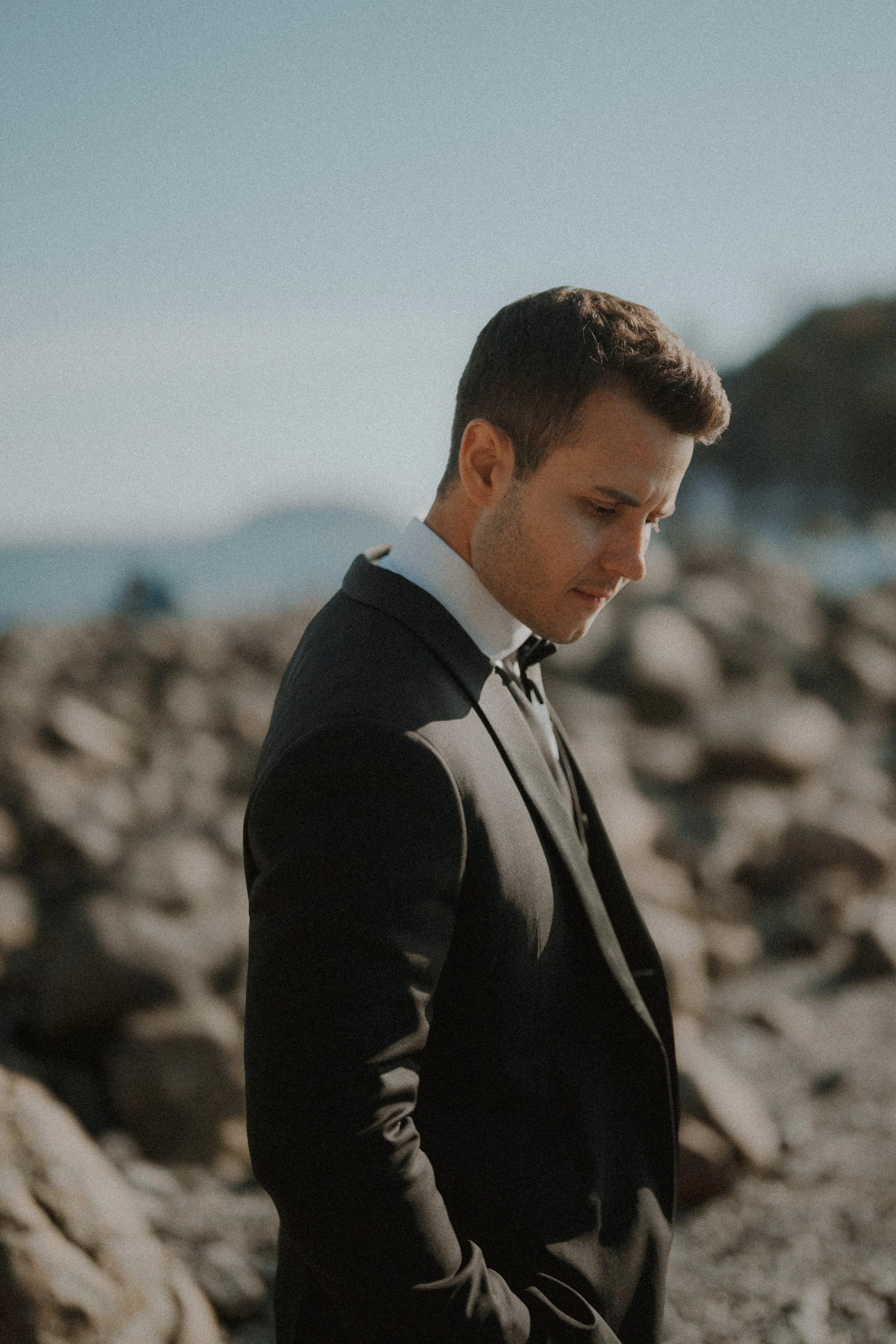 Groom looking down on the rocky shoreline at Whytecliff Park.