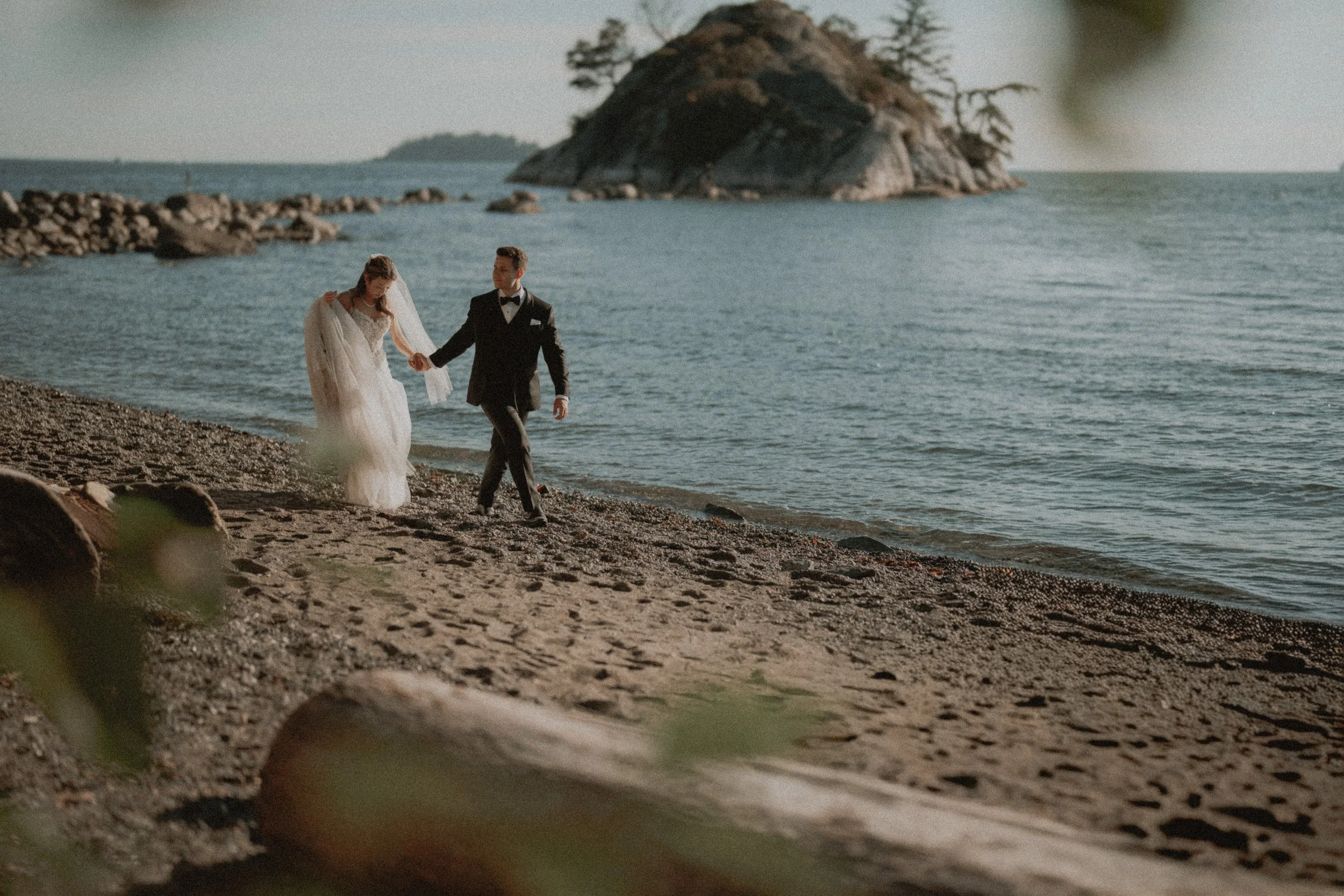 Couple strolling together beside the calm sea at Whytecliff Park.