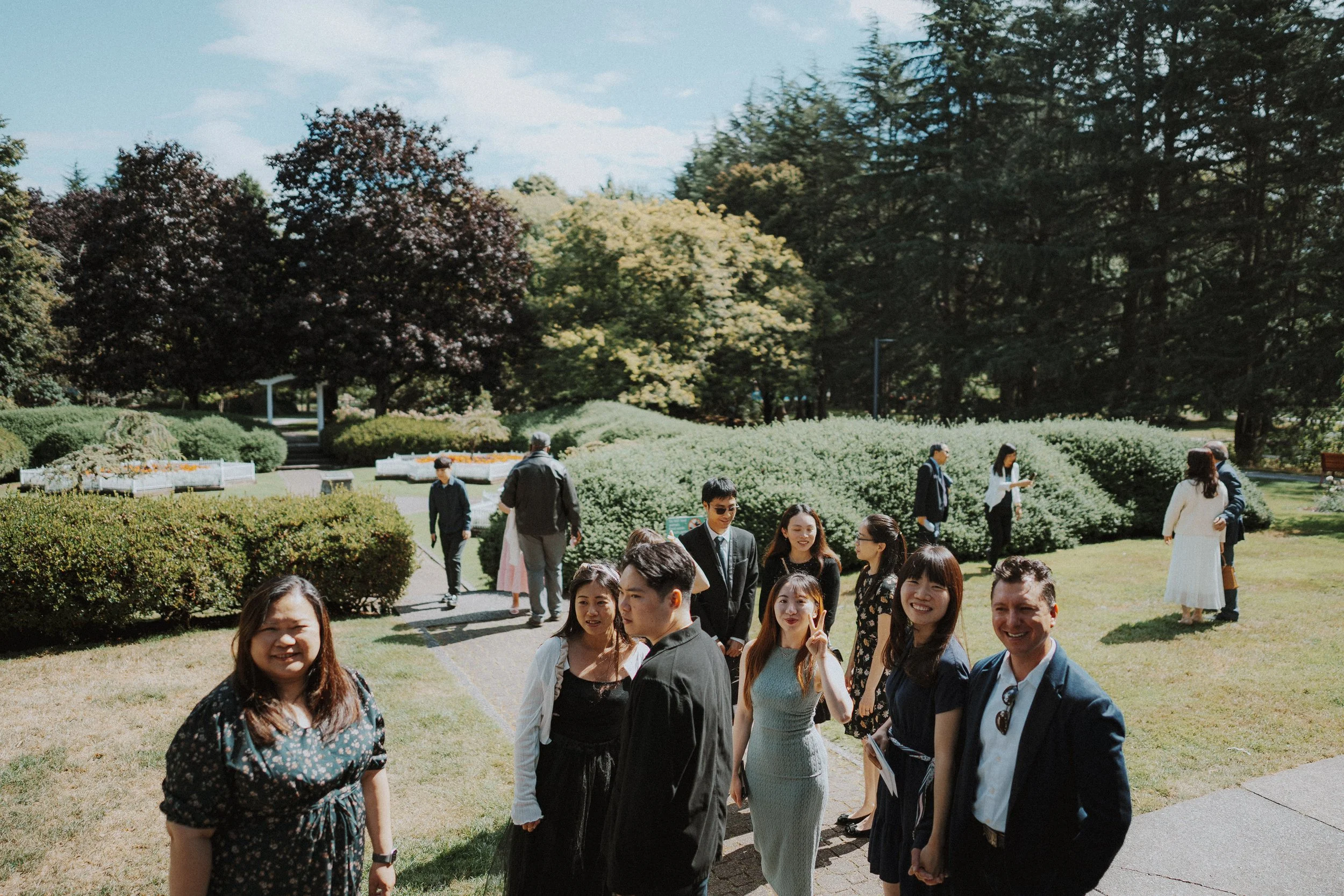 Wedding guests gathering on the garden path outside Minoru Chapel.
