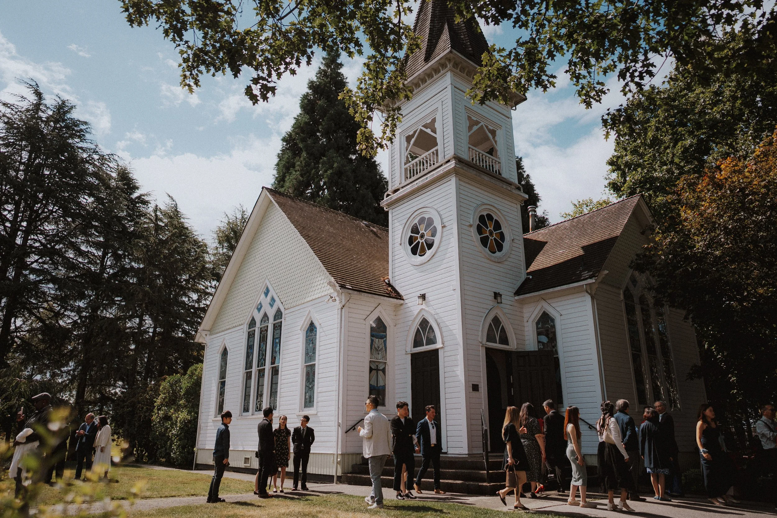 Guests arriving beside Minoru Chapel's white tower and arched windows.
