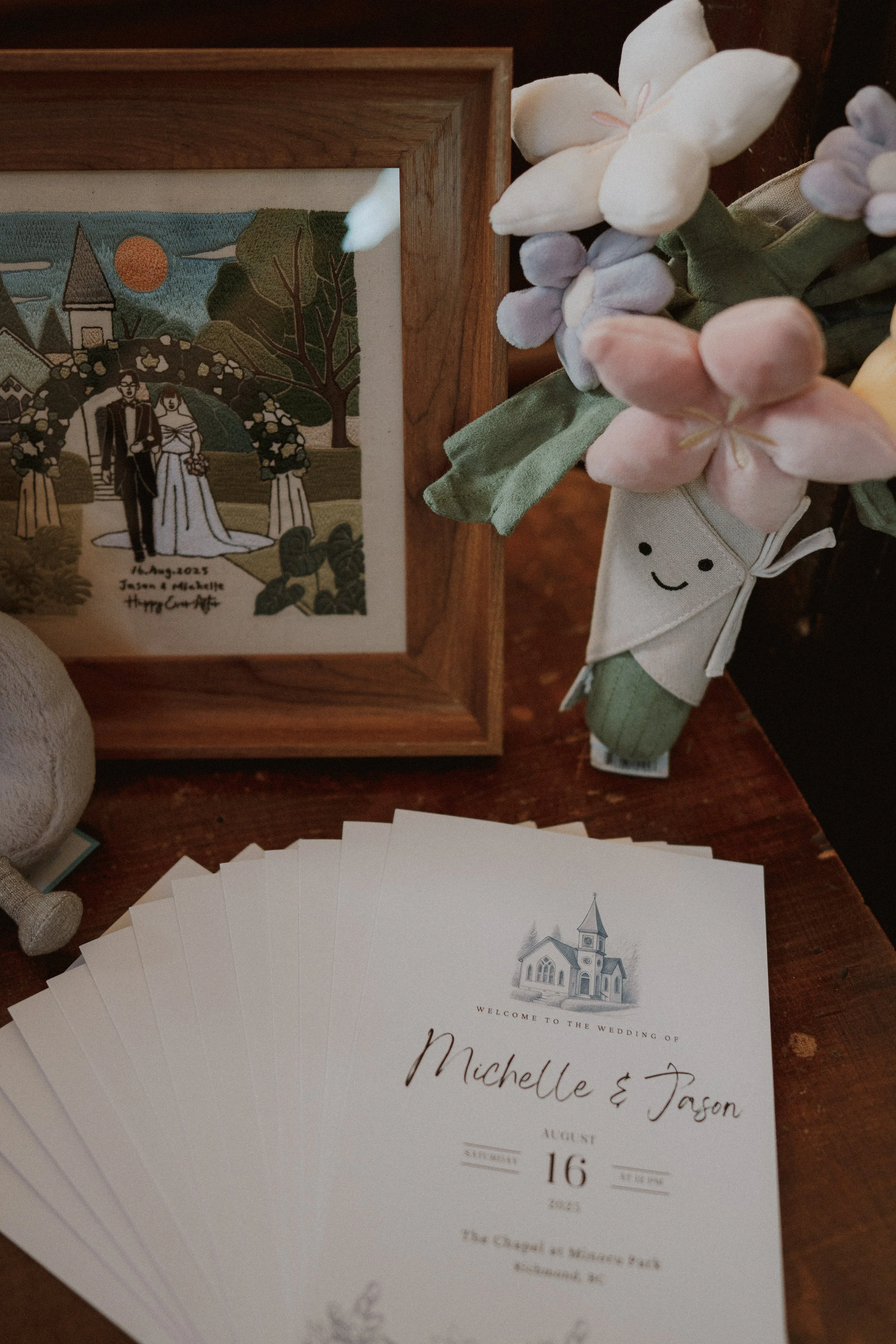 Wedding stationery, a framed photograph and floral decorations on a table.