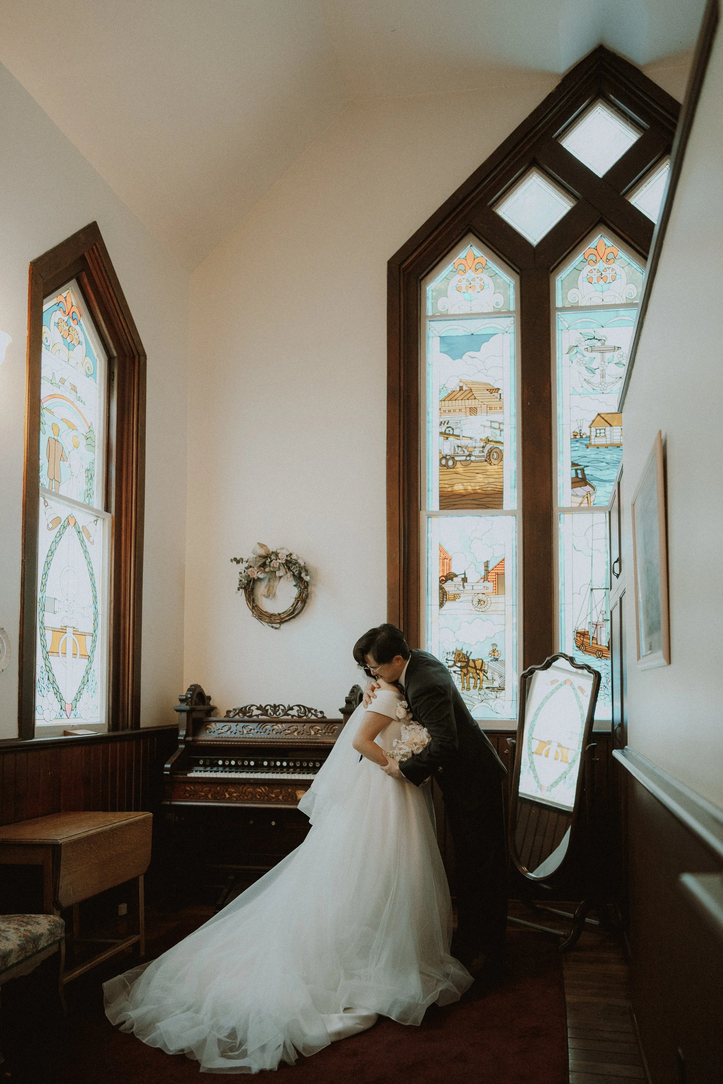 Couple embracing in a quiet corner of Minoru Chapel before the ceremony.