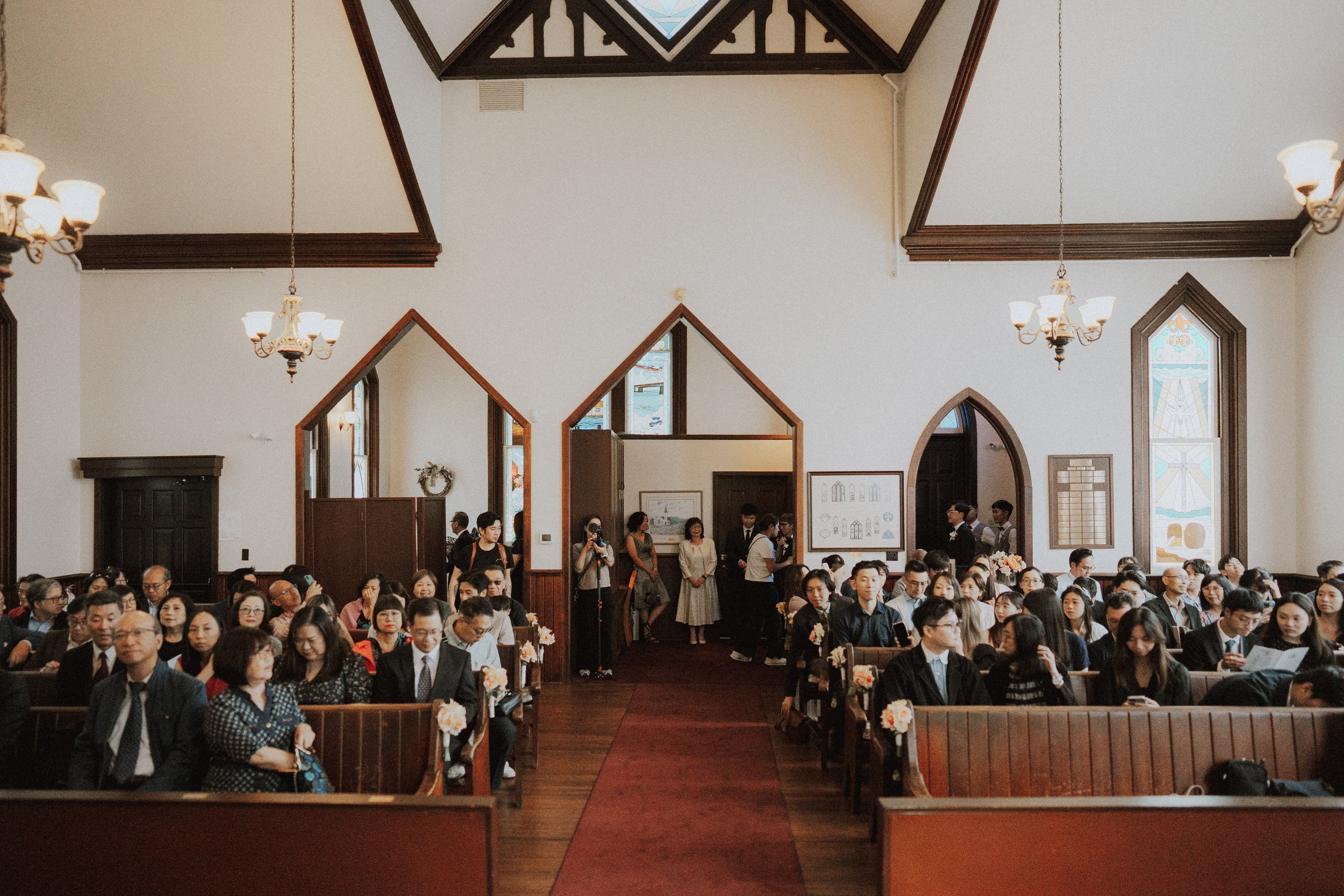 Wide view down Minoru Chapel's central aisle with guests seated on both sides.