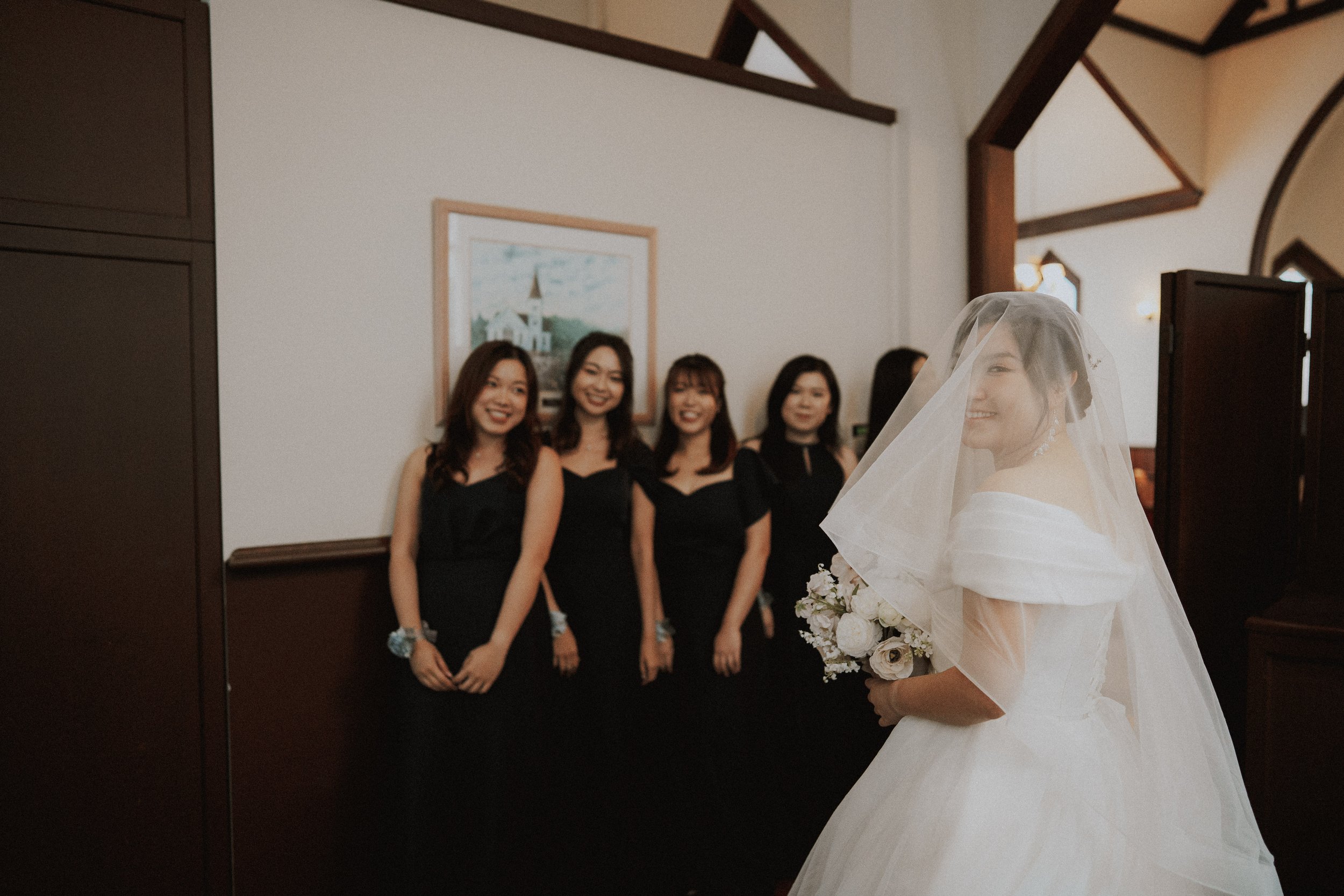 Bride glancing back toward bridesmaids before entering the ceremony.