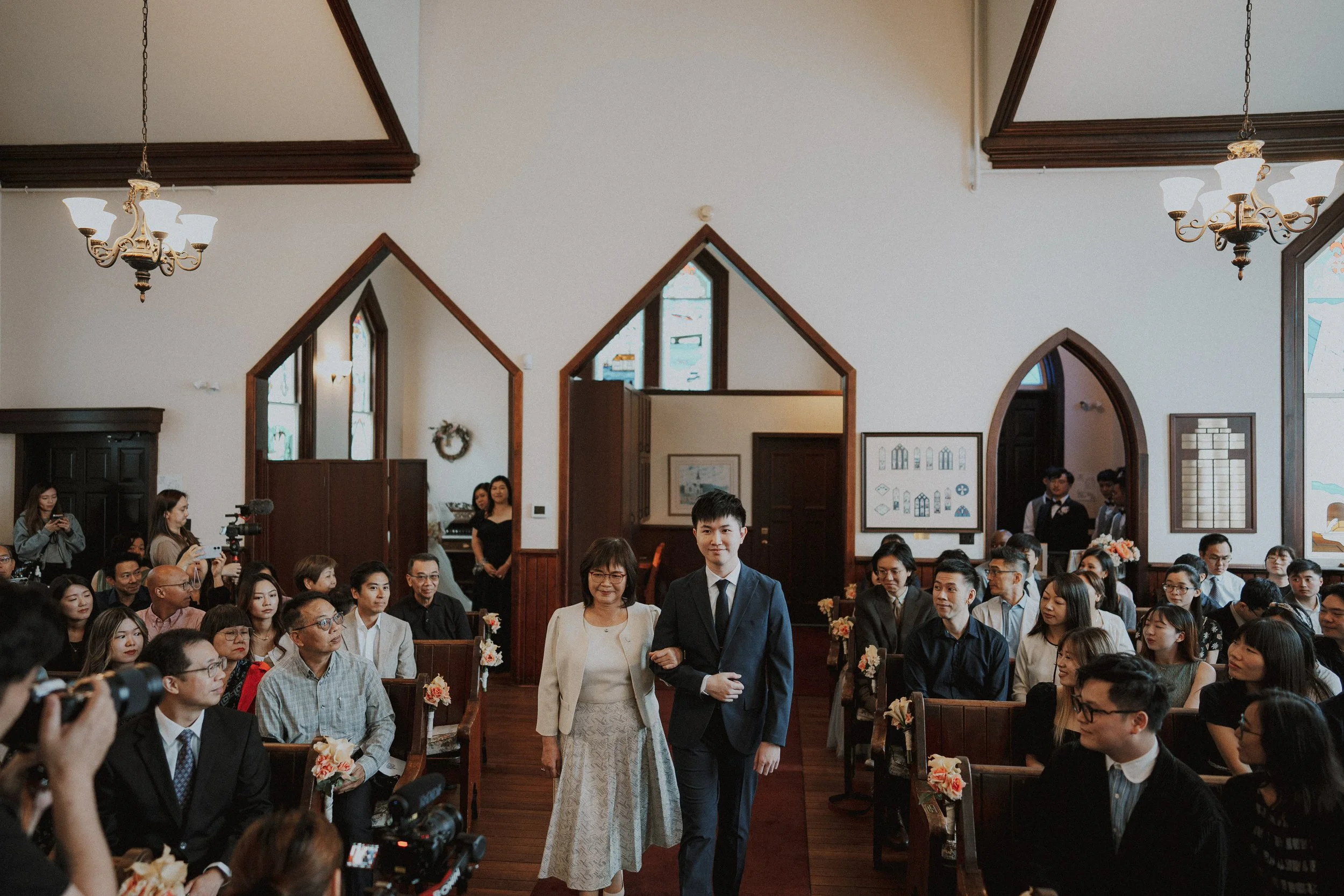 Bride walking down Minoru Chapel's aisle with two accompanying guests.