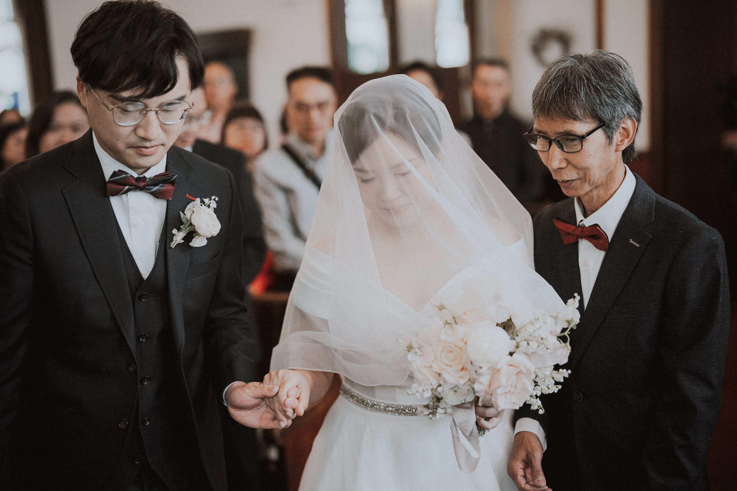 Bride between the groom and an accompanying guest during the ceremony.