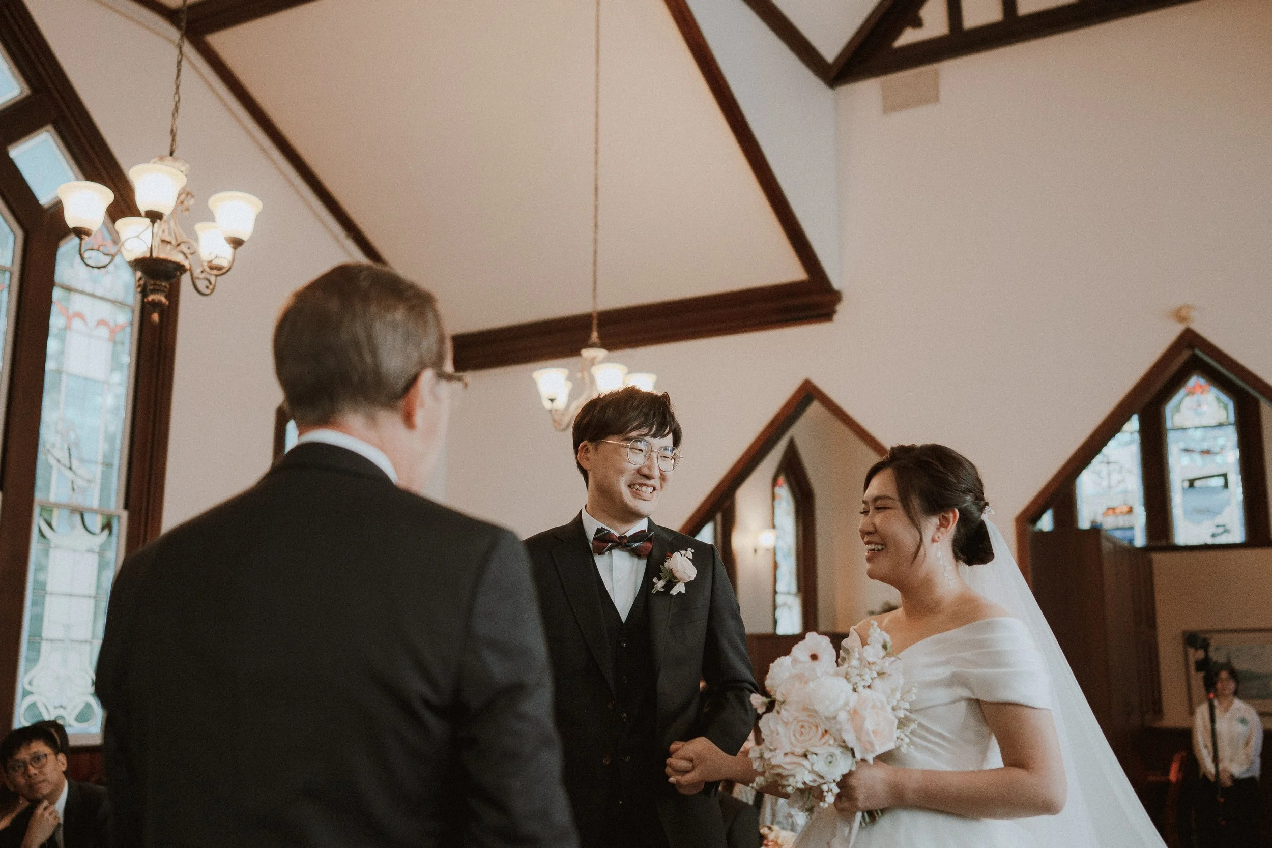 Bride and groom laughing together during their wedding ceremony.