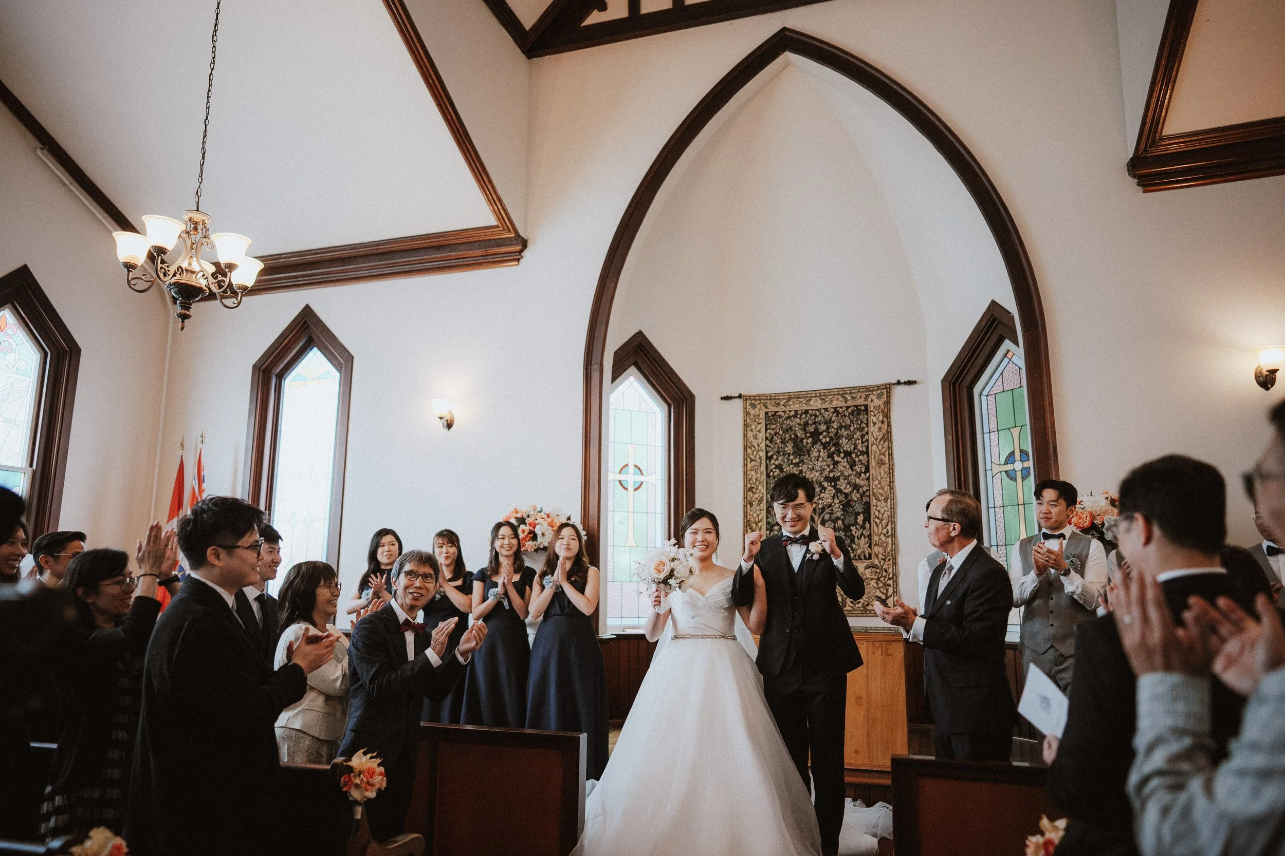 Newlyweds walking through applauding guests after their ceremony.