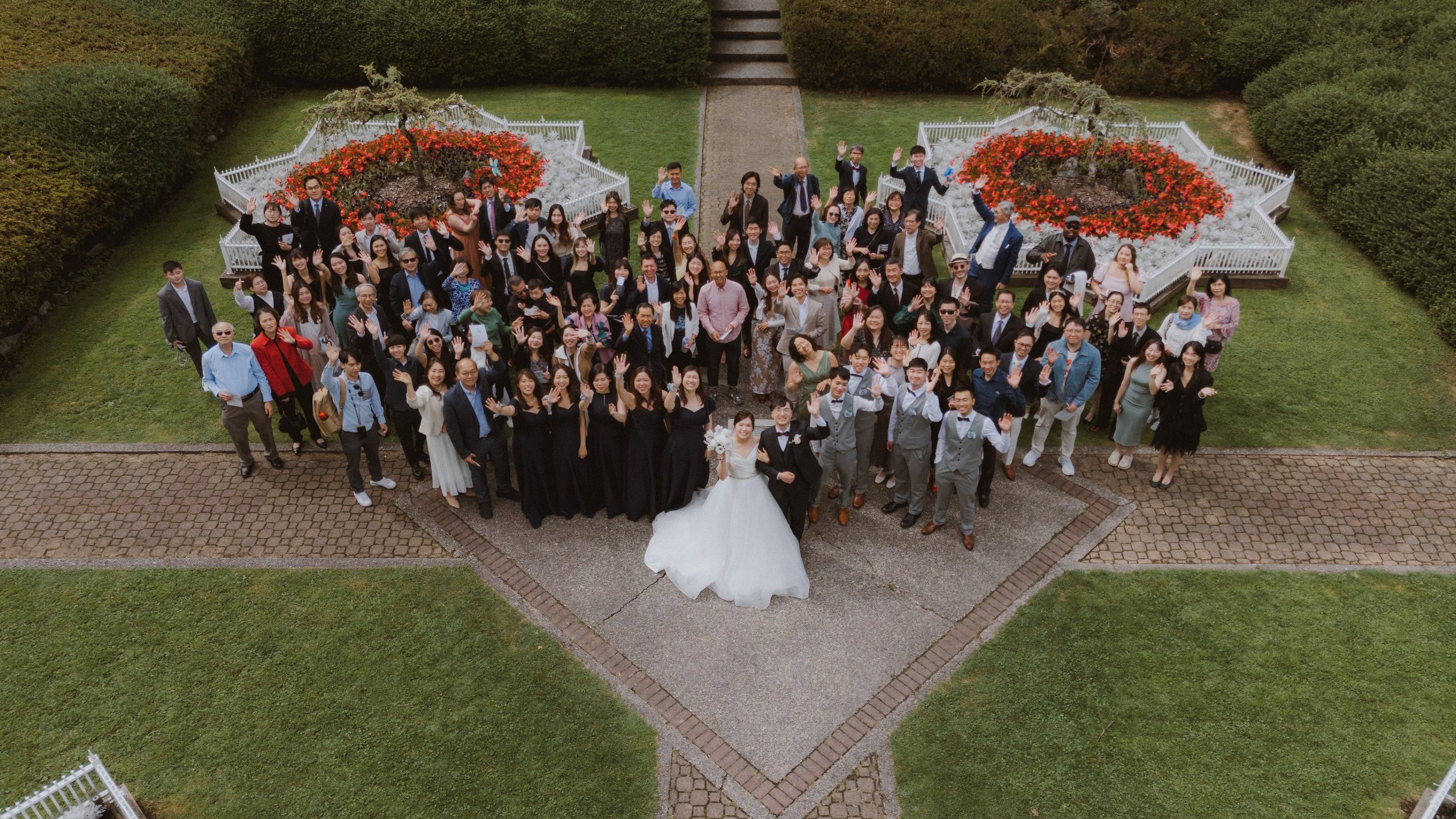 Overhead view of the wedding group between flower beds outside Minoru Chapel.
