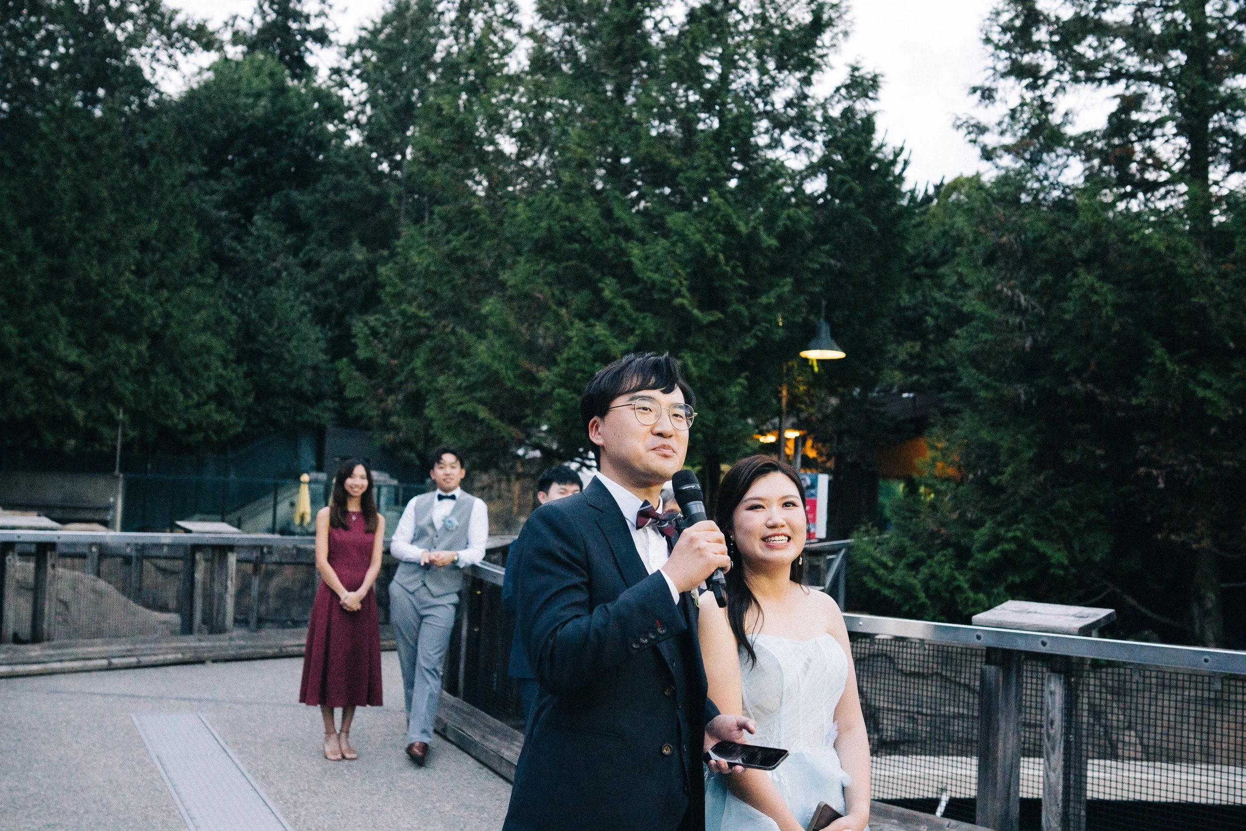 Bride and groom smiling together beside the aquarium pool railing.