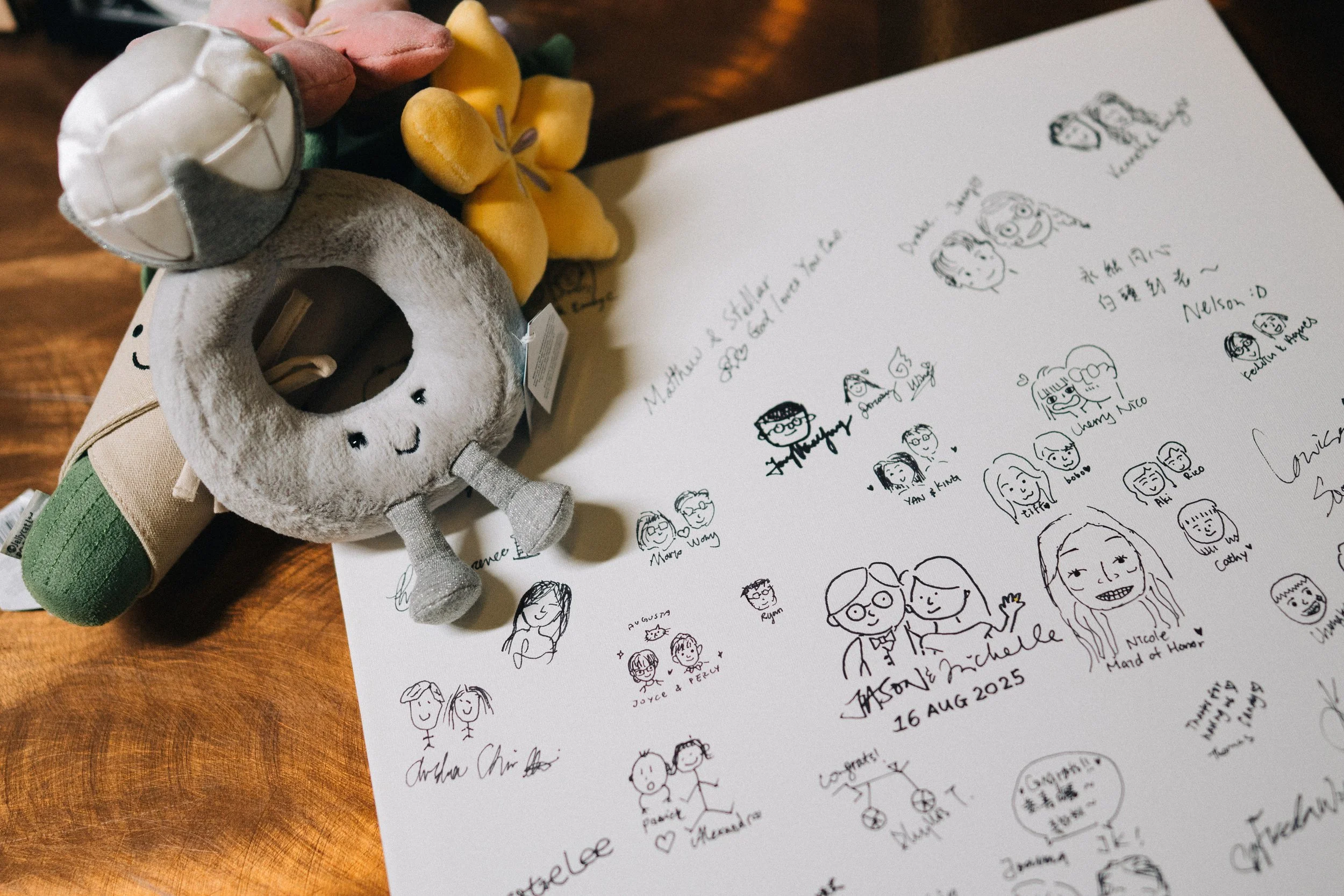 Hand-drawn guestbook portraits beside flowers and a small decorative figure.