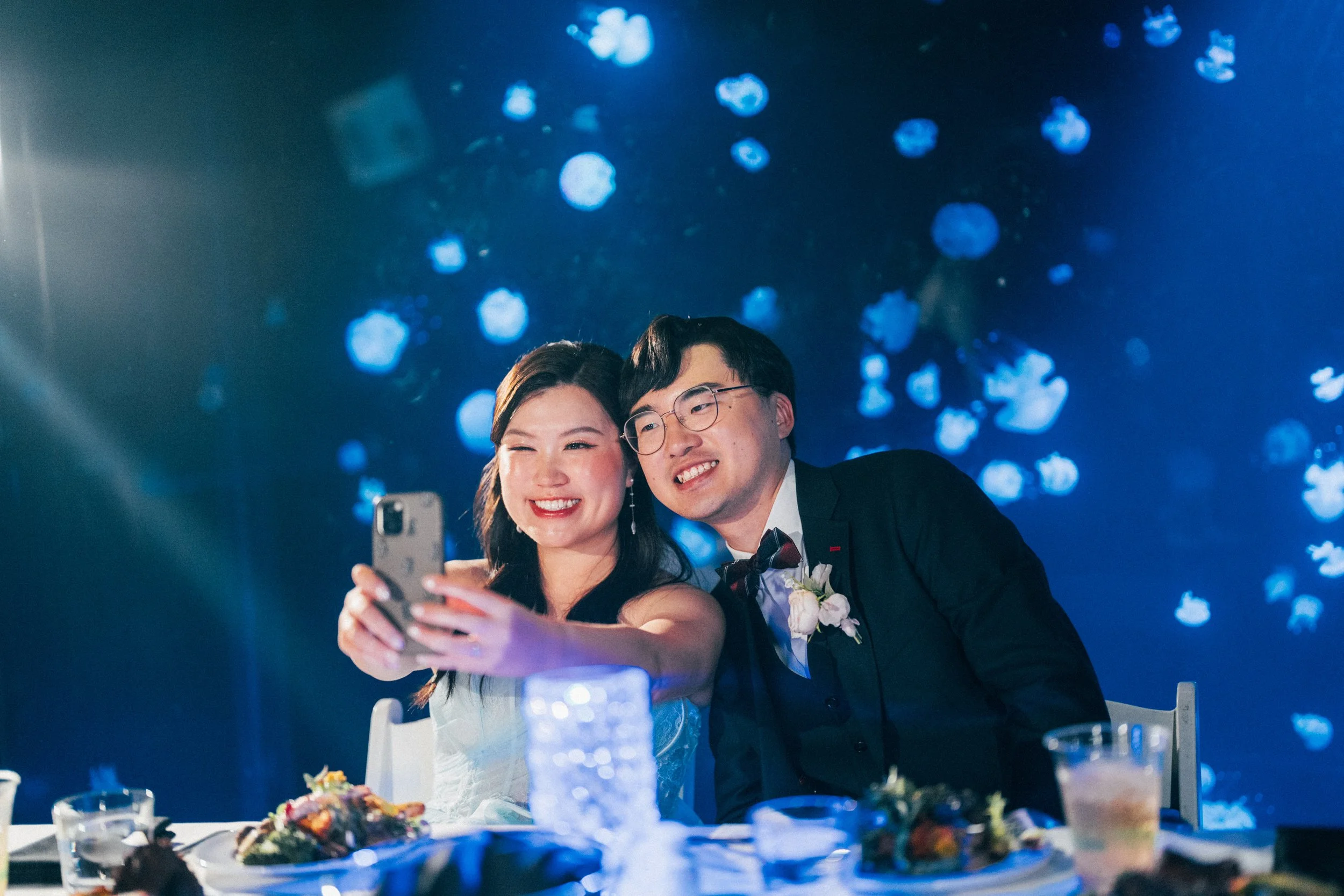 Newlyweds taking a selfie at their Vancouver Aquarium wedding reception.