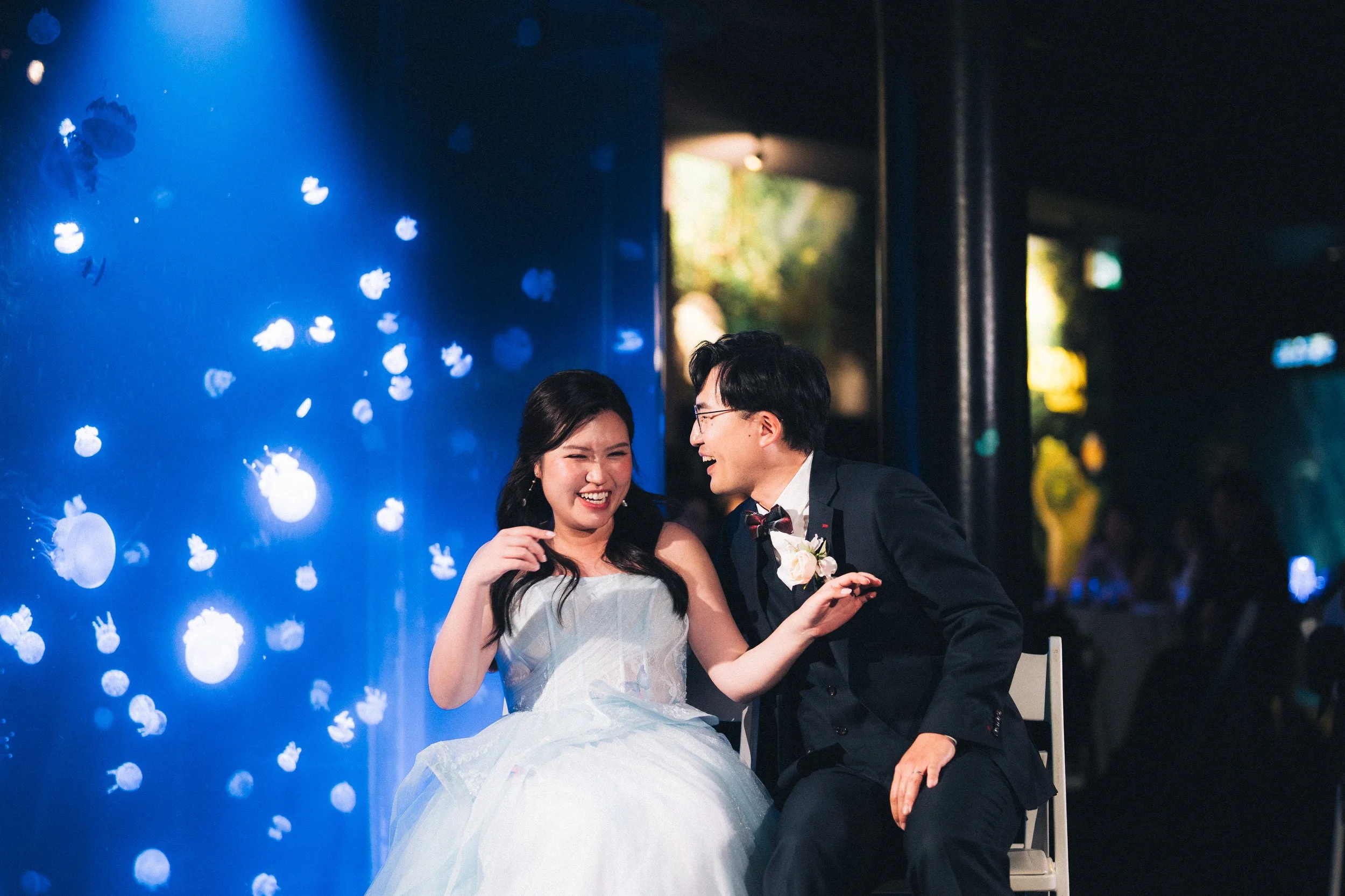 Bride and groom laughing during a reception game at Vancouver Aquarium.