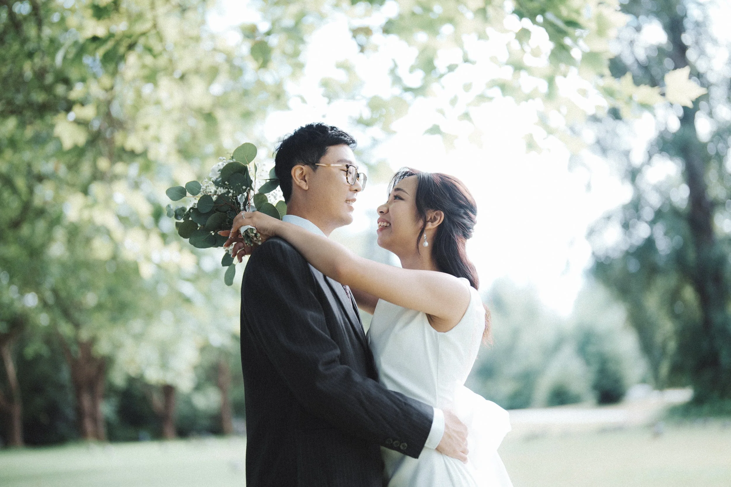 Chloe and Marco sharing an intimate moment beneath Stanley Park trees