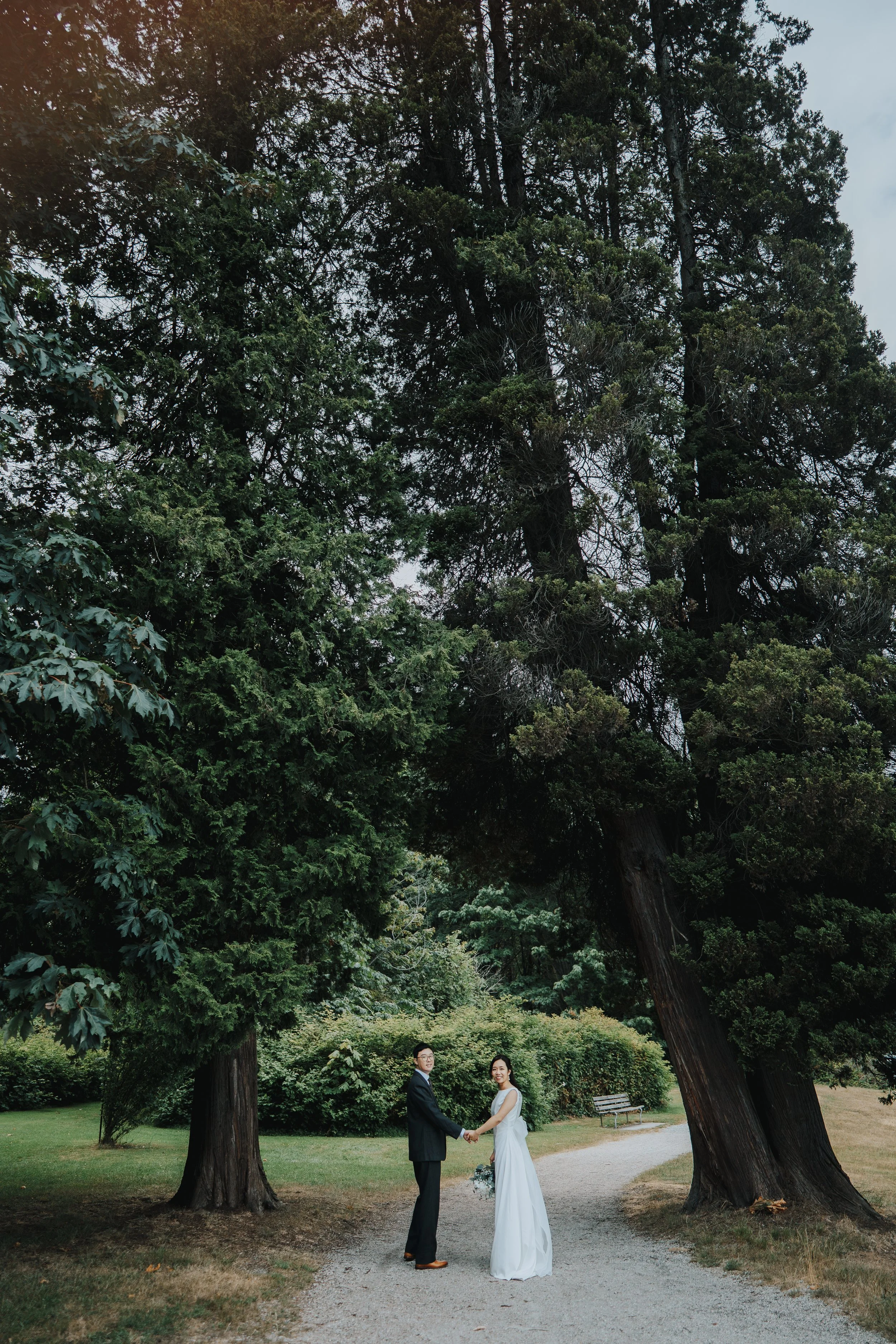 Chloe in a long veil beneath the tall trees at Stanley Park
