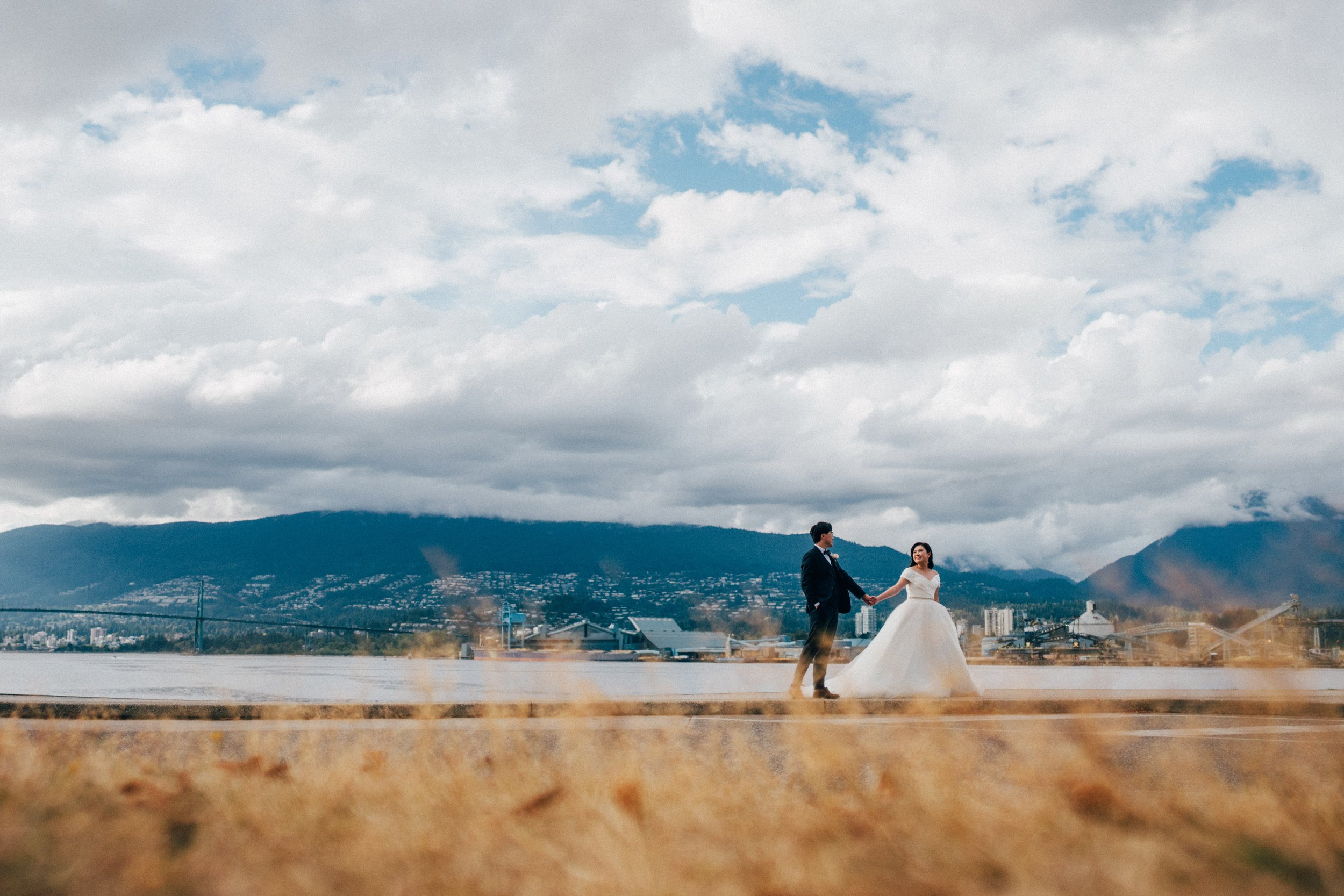  The couple walks along the water with the stunning  Vancouver  North Shore mountains in the distance. 