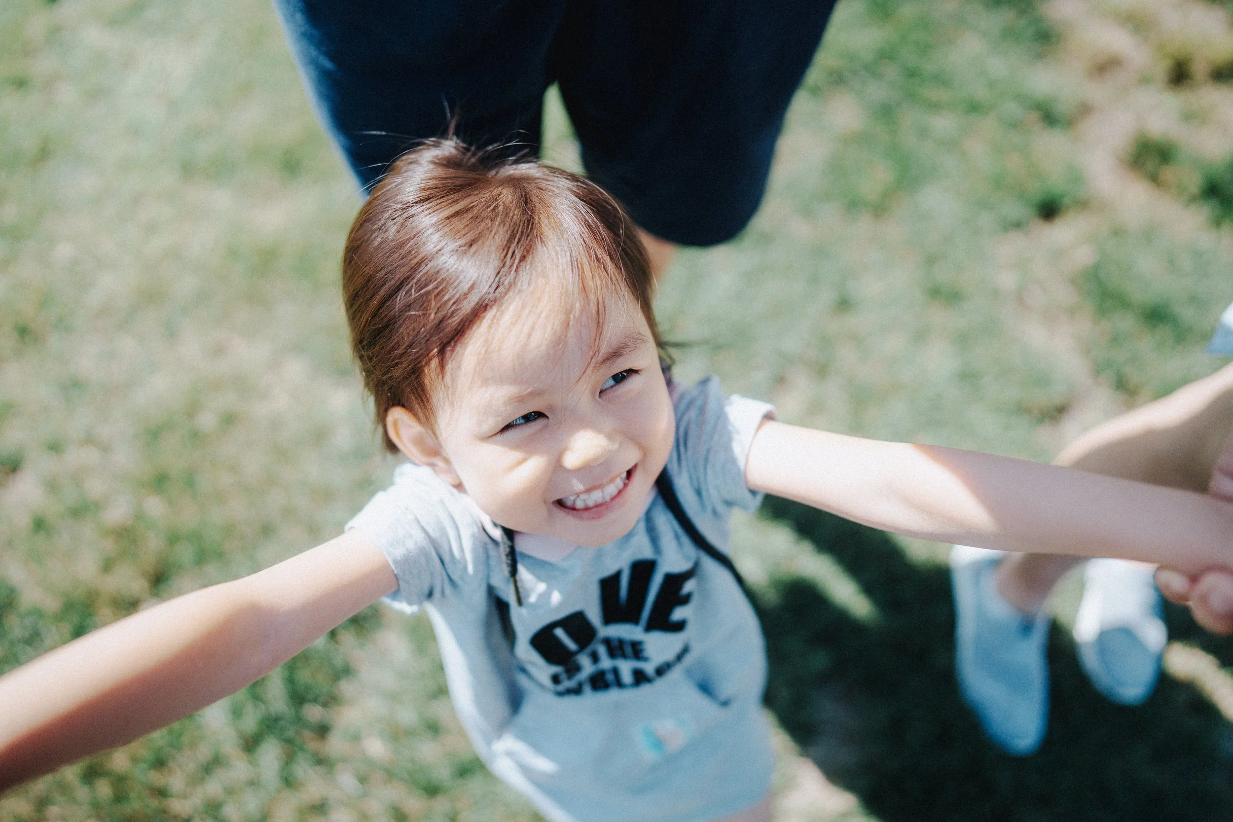 Child hugging adult’s arm outdoors at Richmond Country Farms