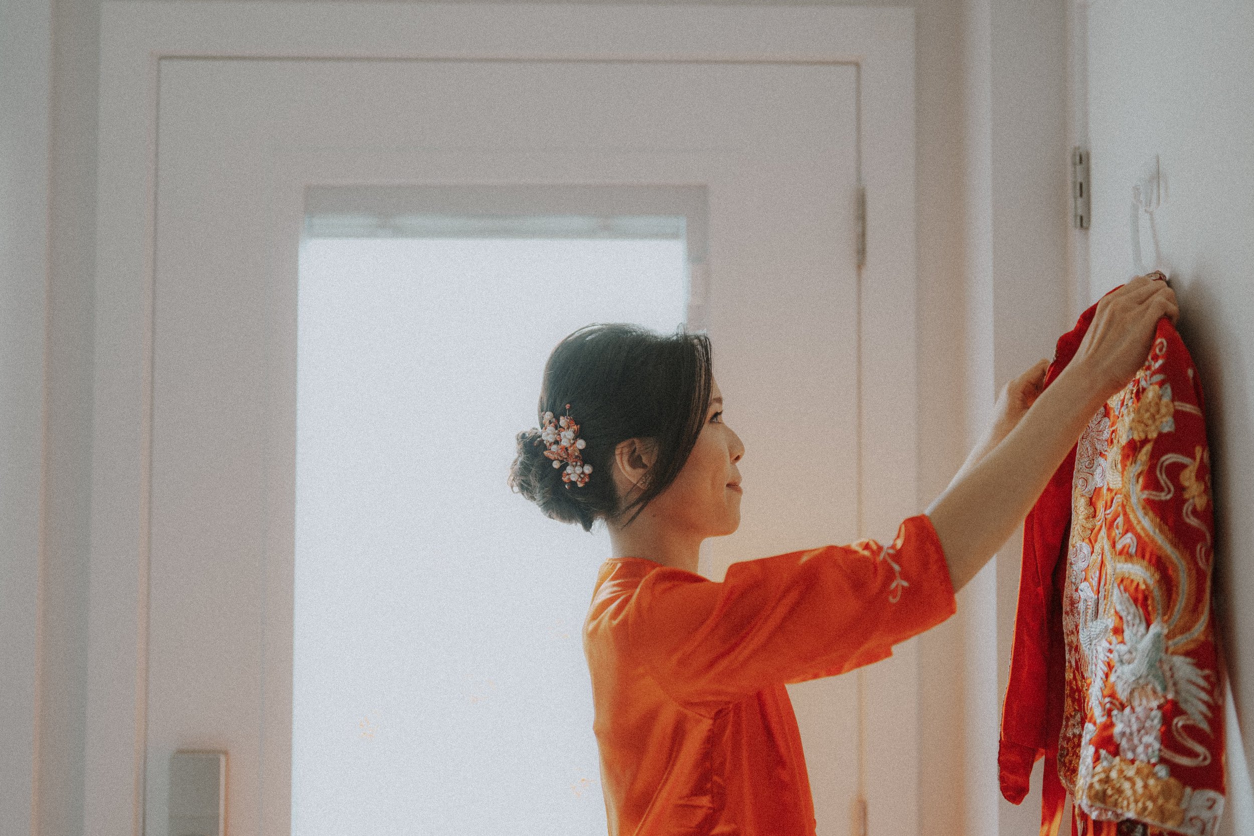  The bride adjusting her beautiful  Qun Gua , a quiet moment before the wedding. 