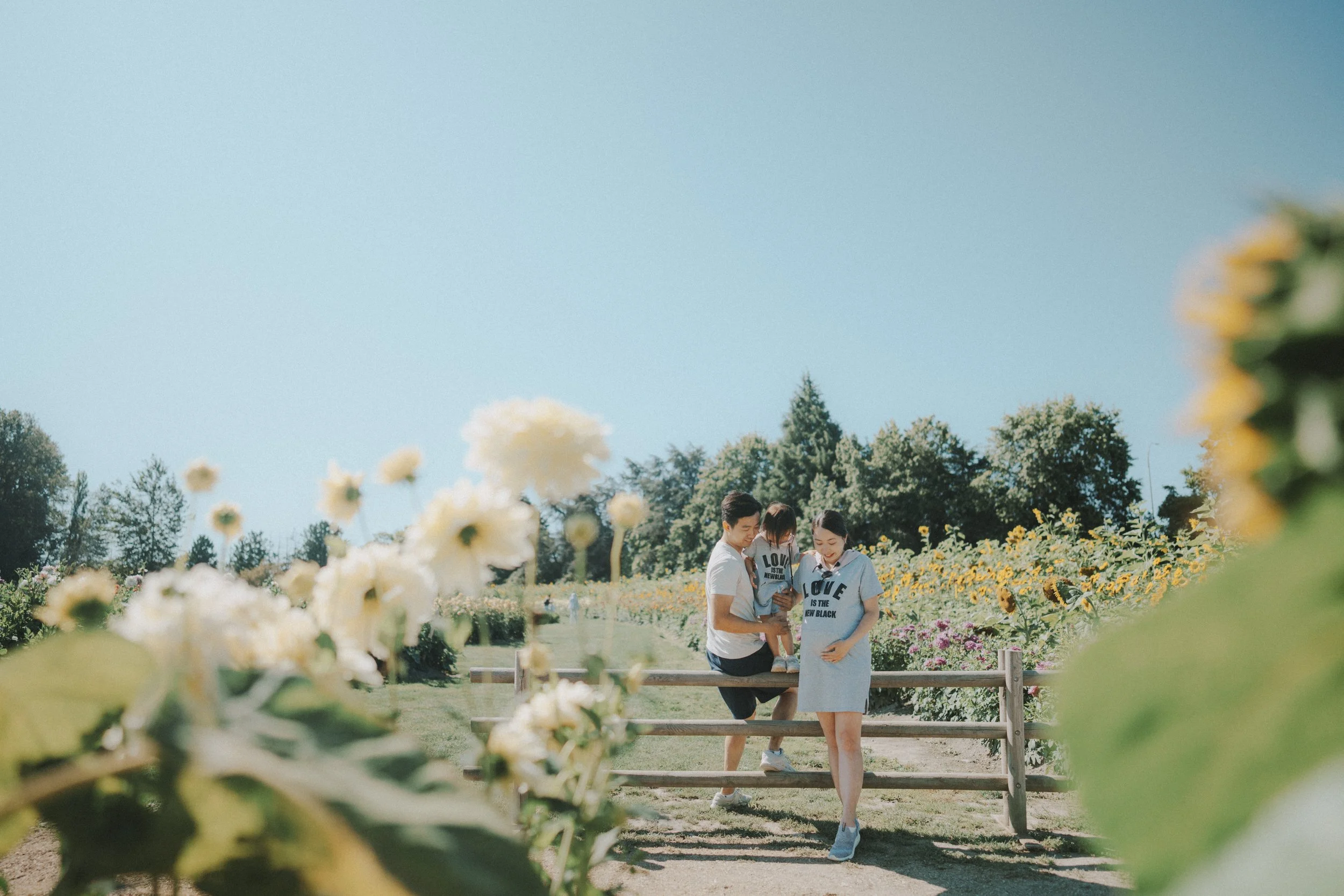  The flowers were bright, the sky was clear, and they stood together in matching shirts. It felt cheerful and close—like a little pause in the middle of the day. 