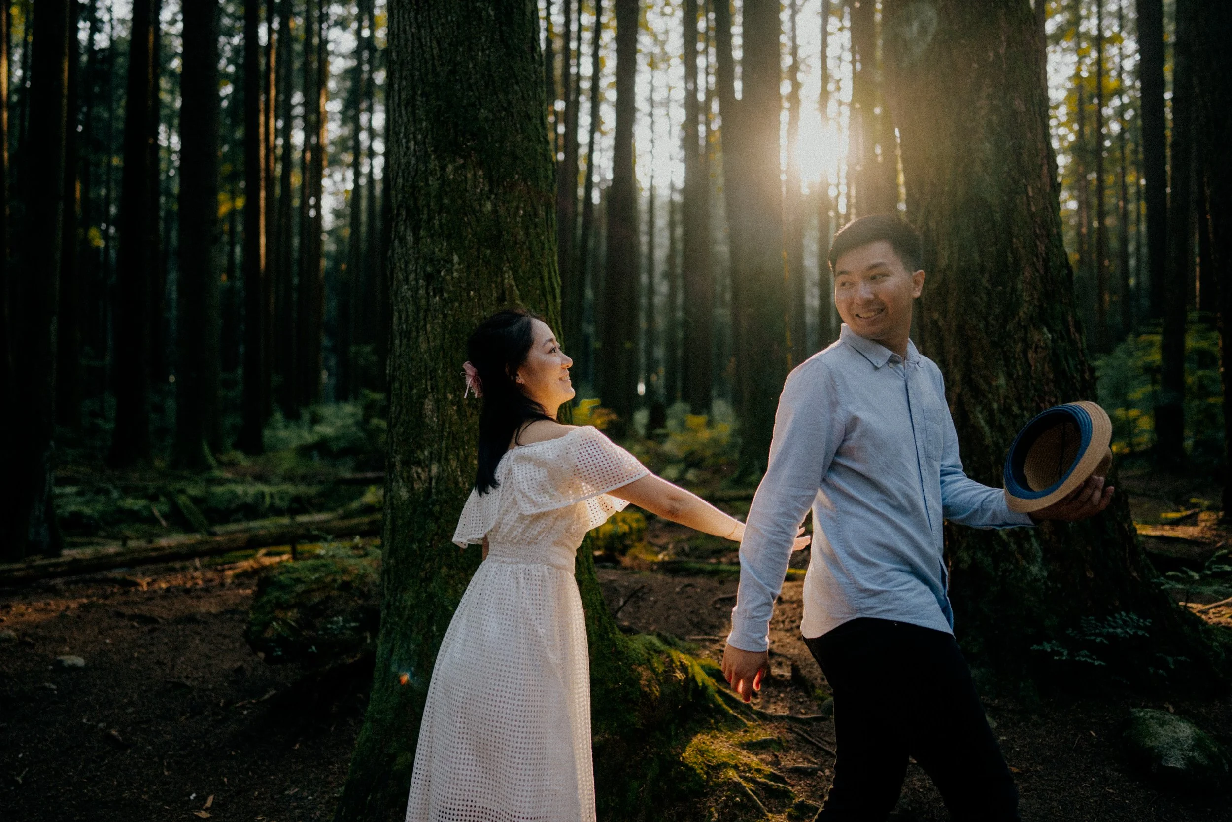  The groom leads the way, sharing a loving glance back at his bride in the golden forest light. 