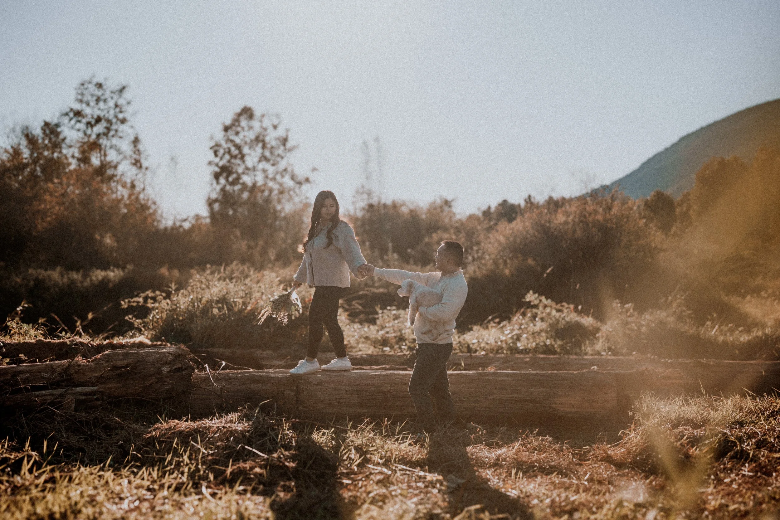 A fun, dynamic shot of the couple walking carefully along a large log. 