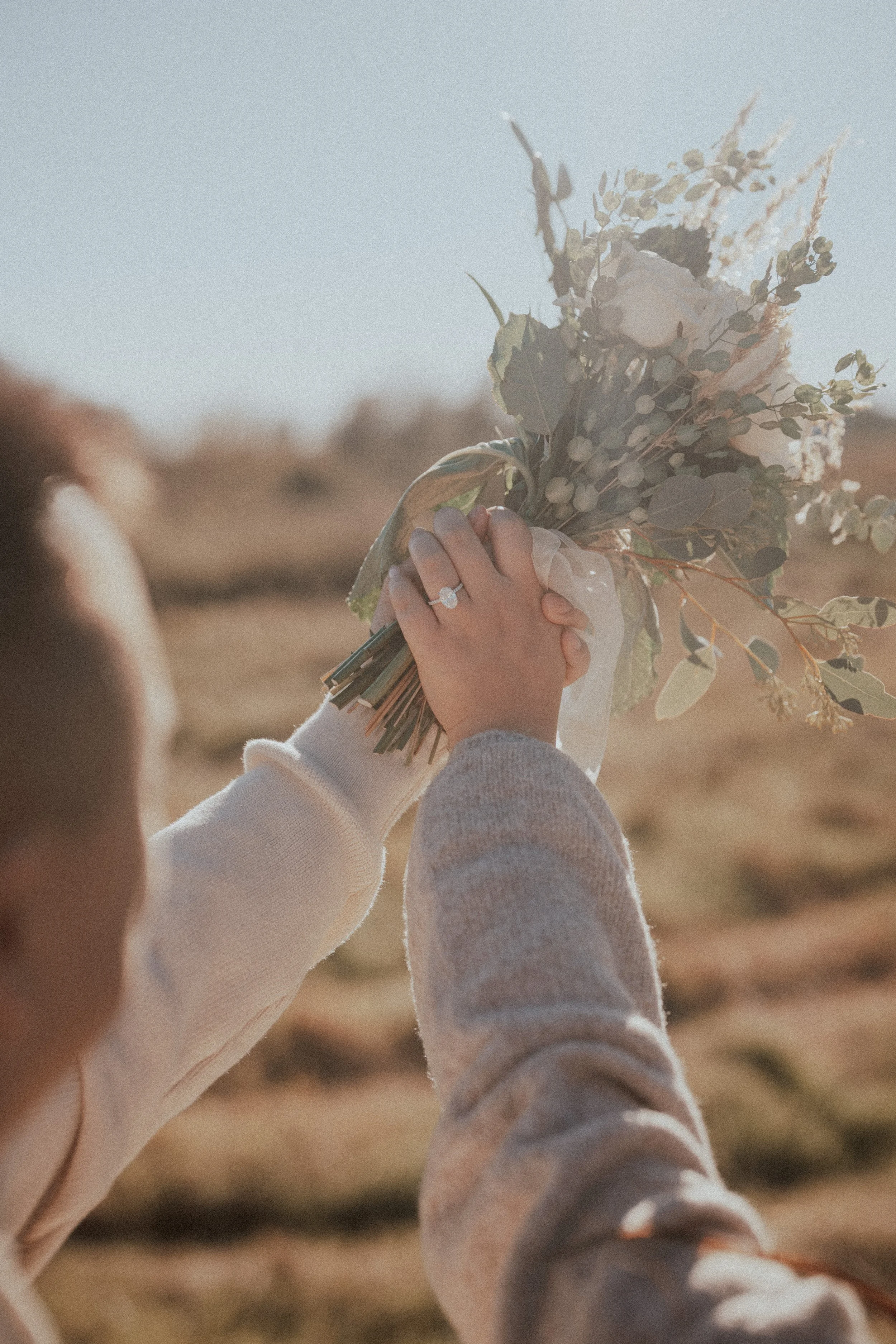  A beautiful detail shot of the bride's hand, bouquet, and sparkling engagement ring. 