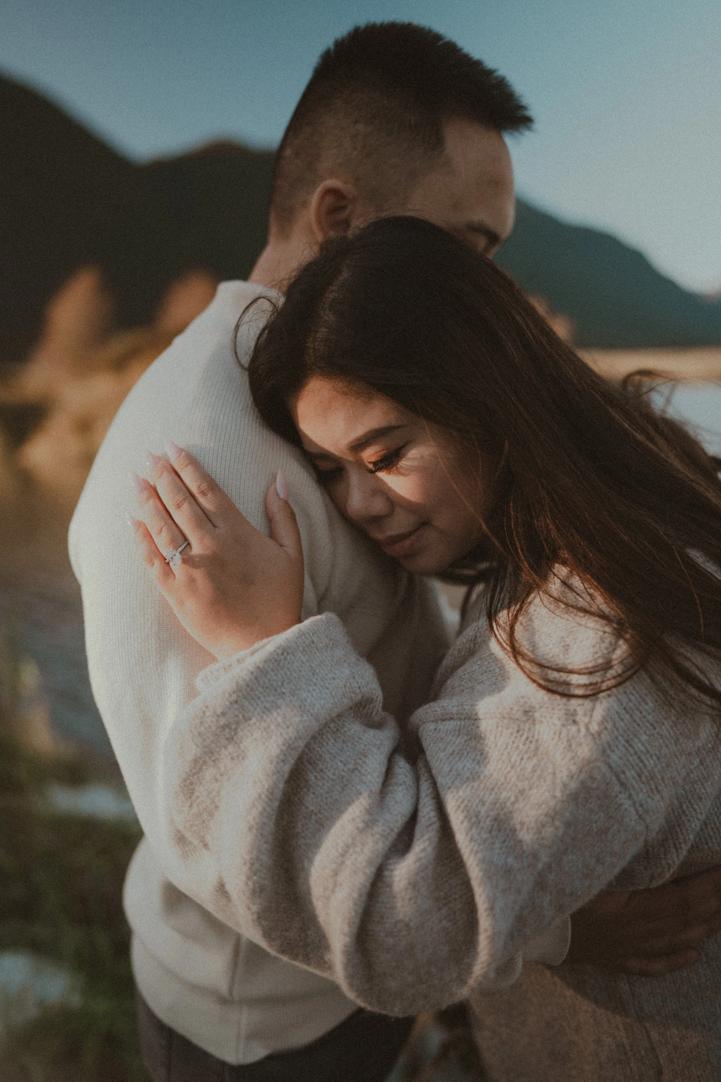  A beautiful portrait capturing the sincere embrace and the glowing engagement ring in the warm light. 