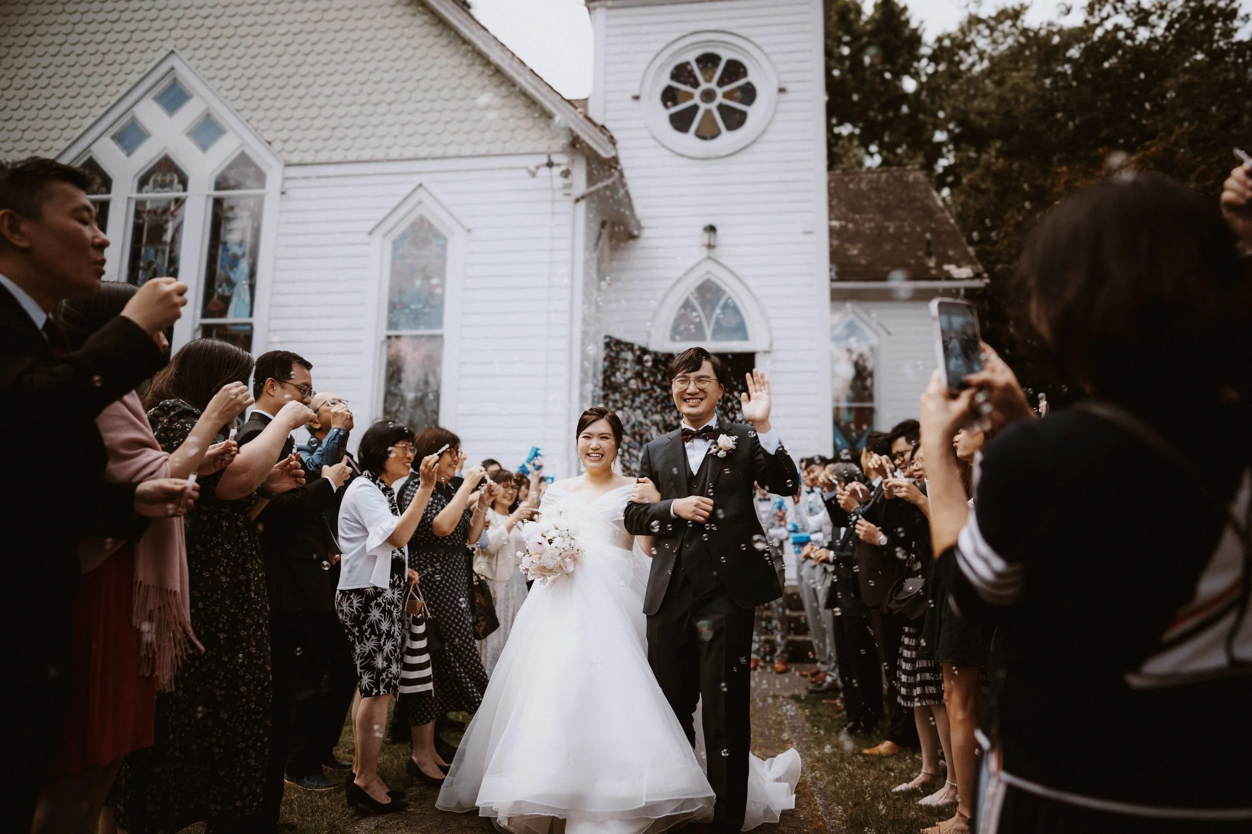  A joyful recessional! The newlyweds walk out of the church, celebrated with bubbles and applause. 