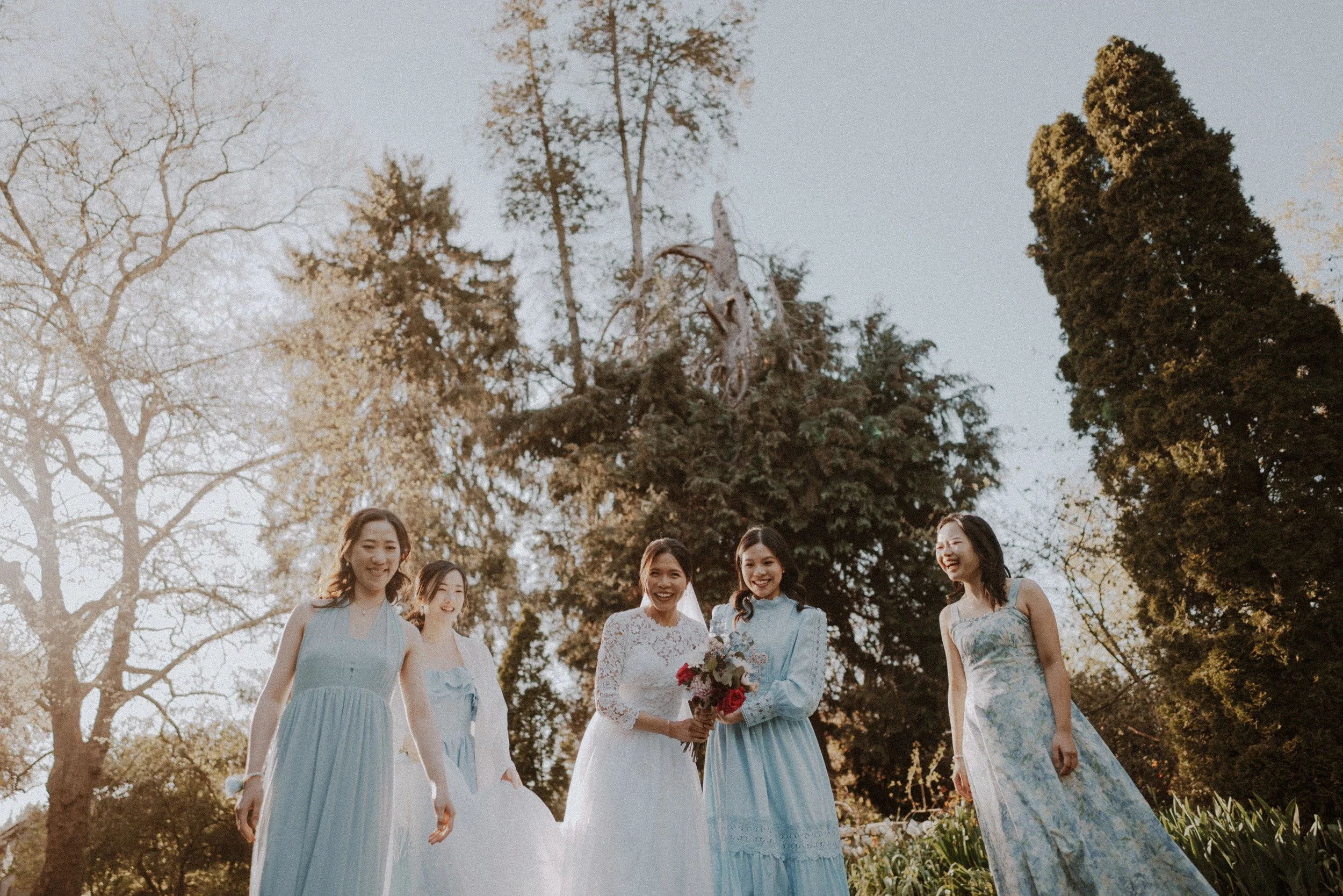  The bride and her bridesmaids sharing a joyful walk in the warm evening light. 