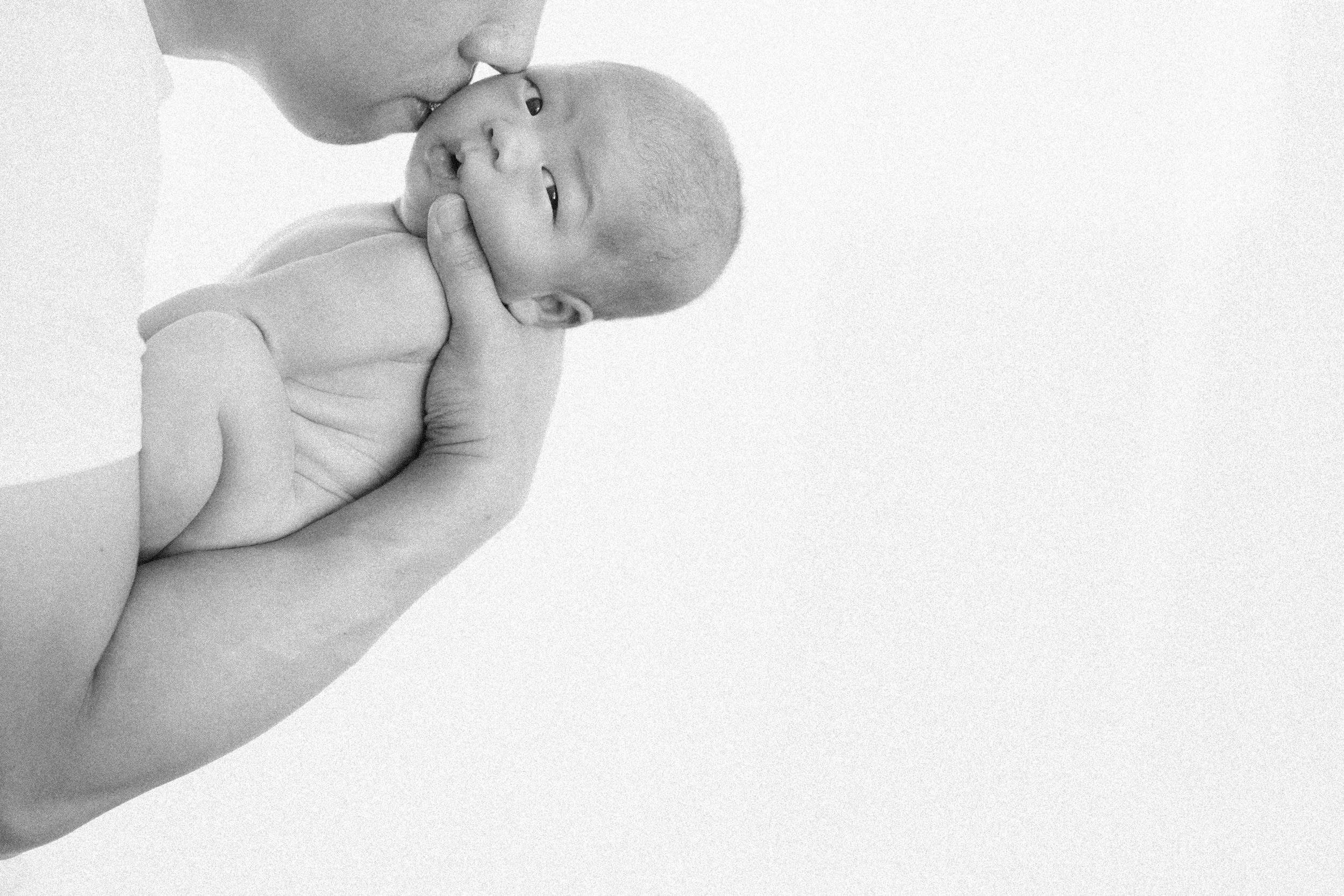  A soft, beautiful moment between father and son, highlighting the gentle, warm light. 