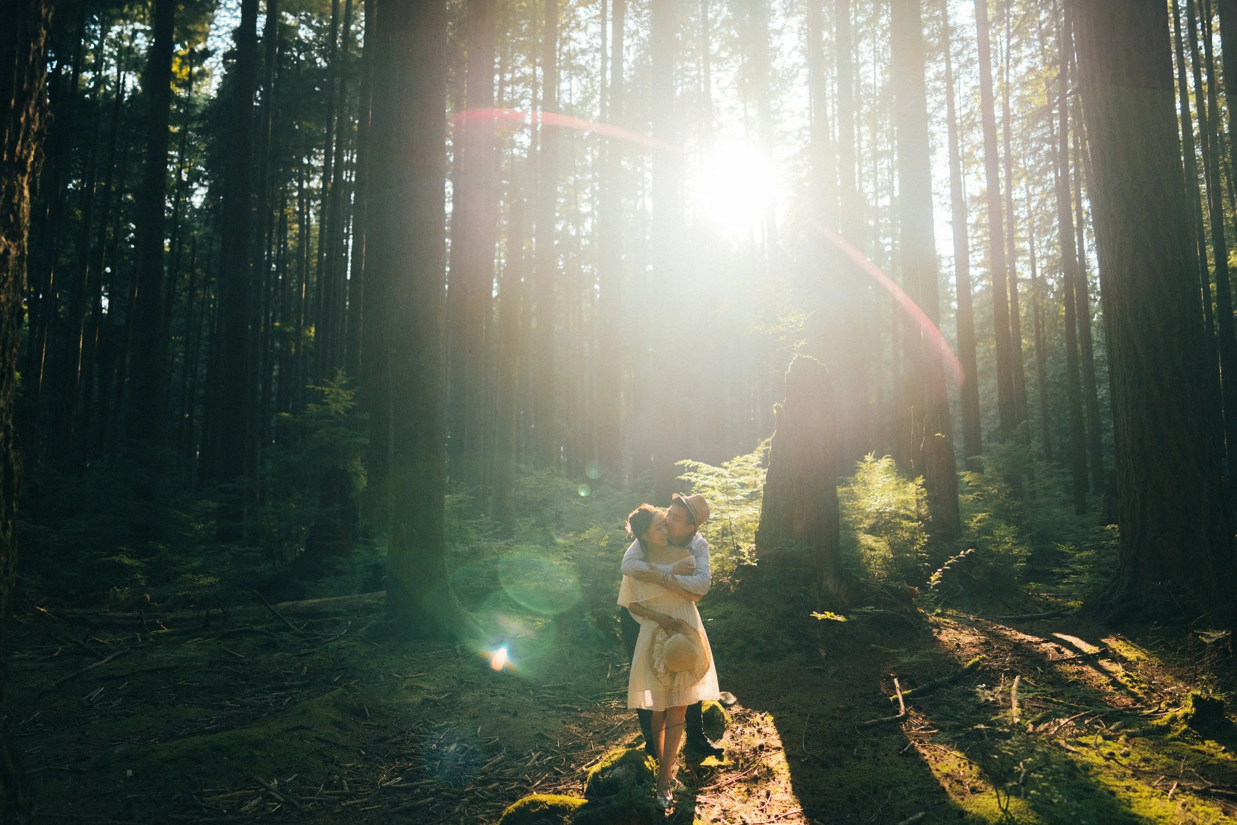 The couple embraces in a stunning sun flare shot, highlighting the magical light deep within the forest. 