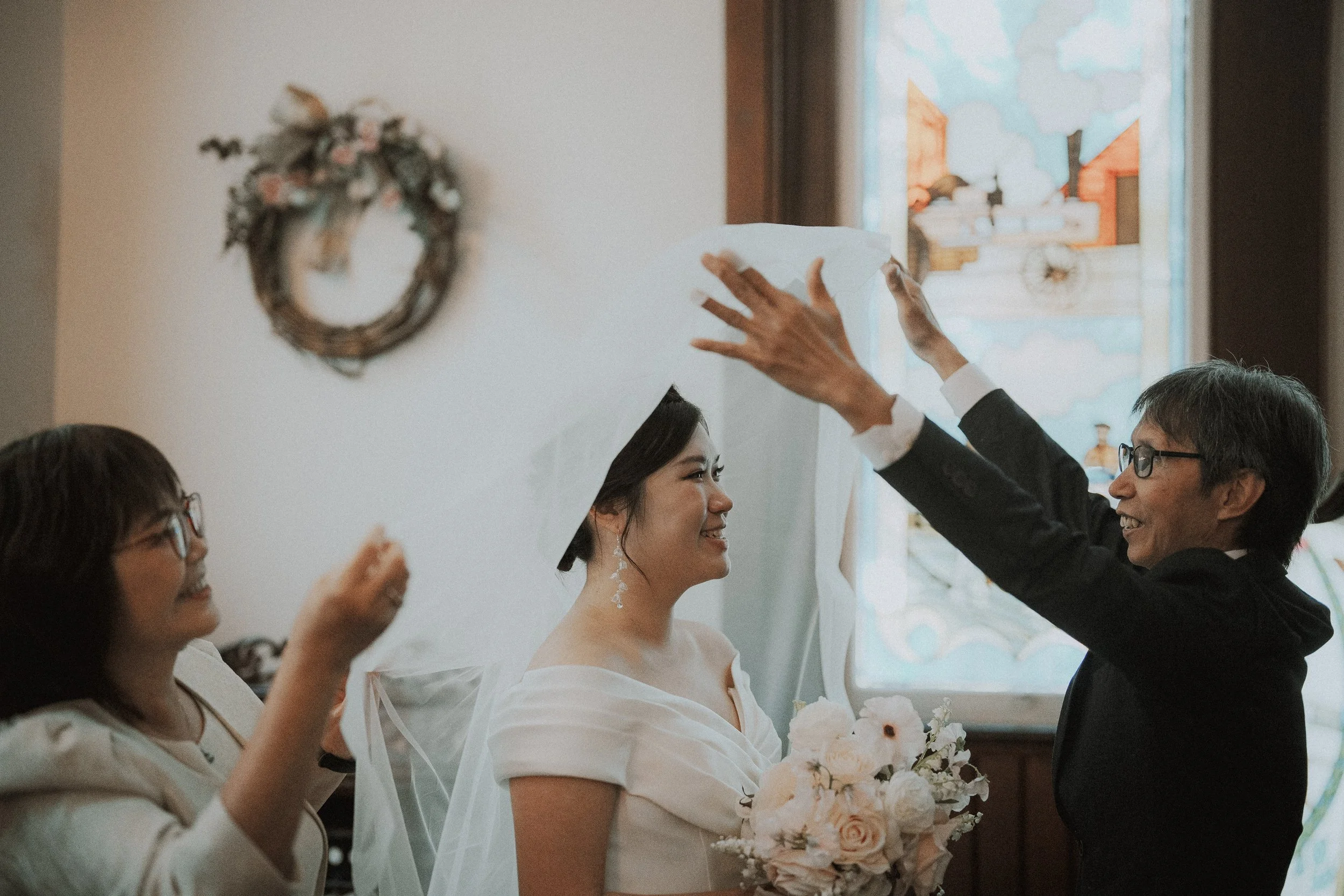  The  bride  and her bridesmaids sharing a joyful, candid moment in the church room. 