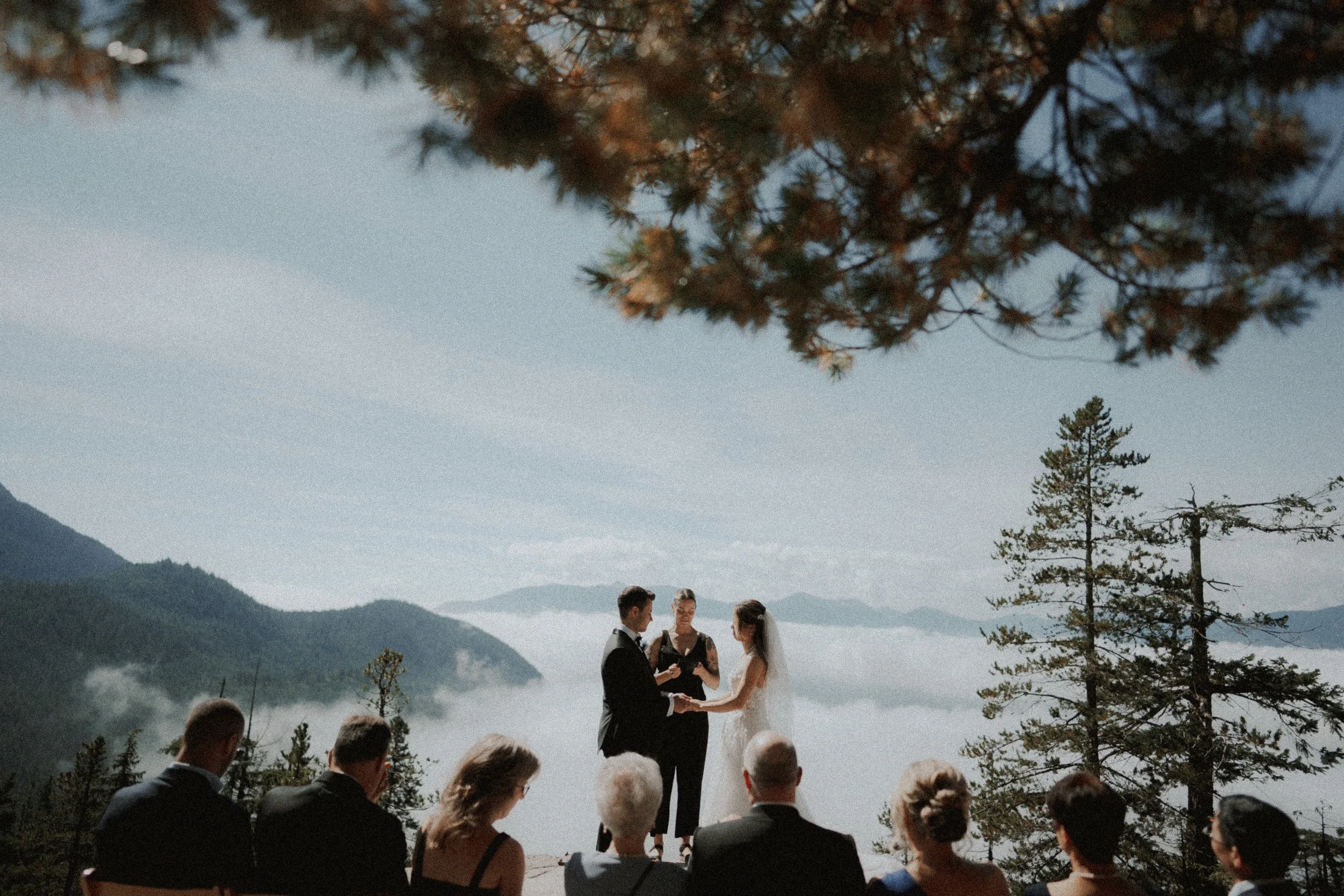  A breathtaking outdoor wedding ceremony on a mountain top in BC. The couple exchanges vows above a layer of clouds, surrounded by family and the stunning Sea to Sky scenery. 