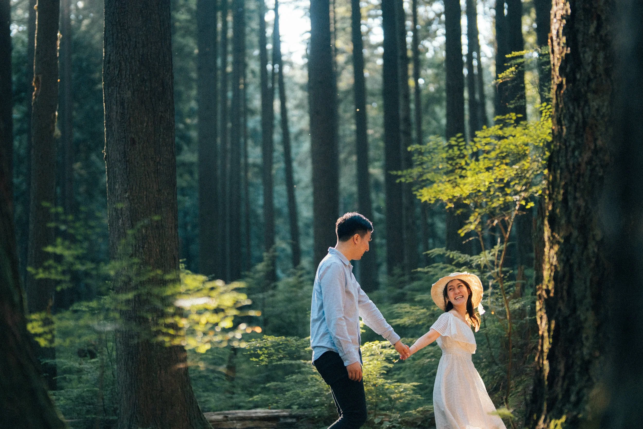  A beautiful portrait of the couple walking along the mossy forest trail, framed by the dense greenery. 