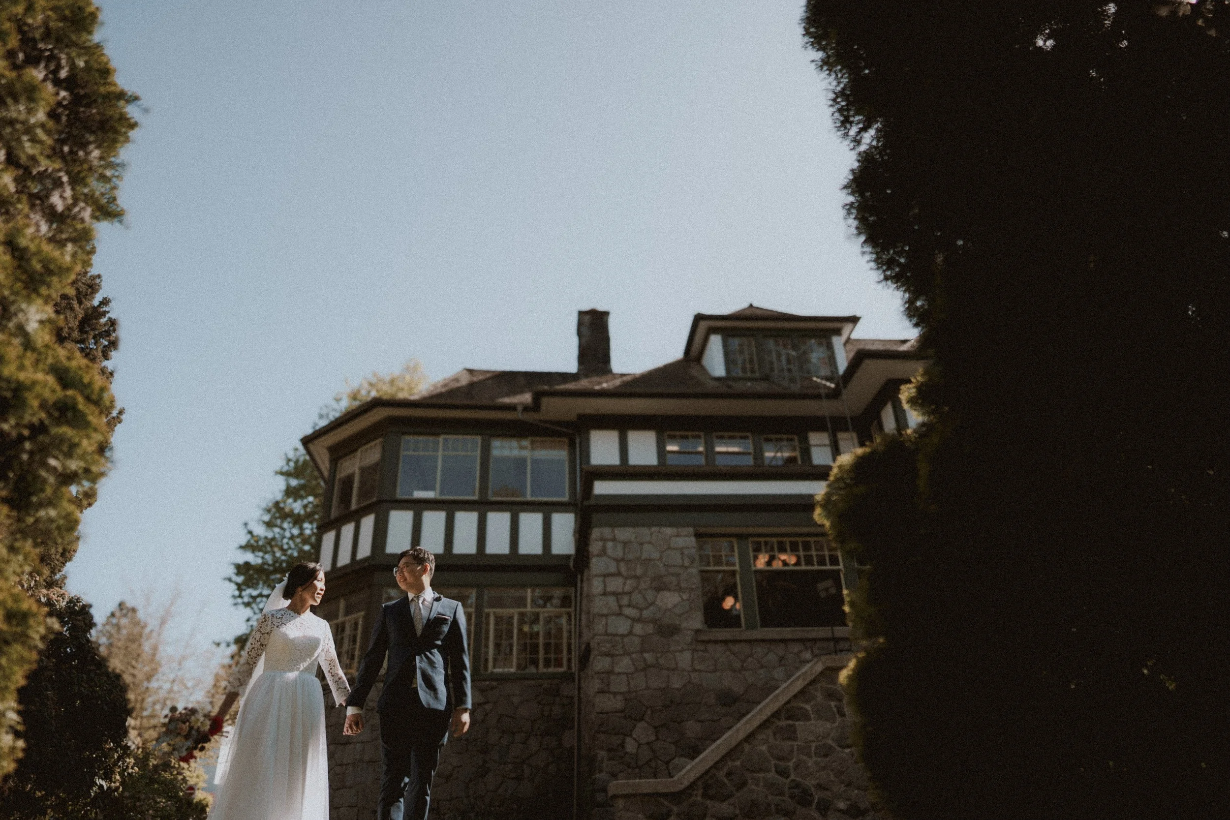  An elegant couple portrait taken in front of a historic stone and timber mansion. Capturing the timeless beauty of this  Vancouver heritage wedding venue . 