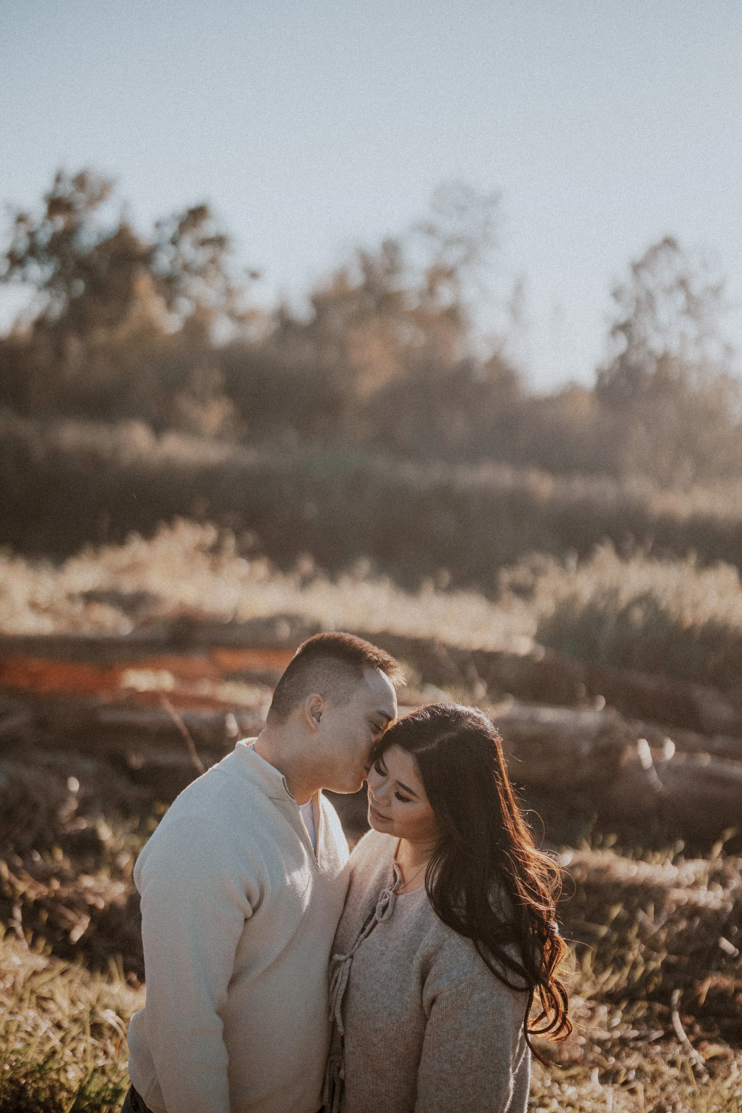  A tender, intimate moment: the groom kisses the bride's forehead, surrounded by the beautiful golden light of the  Pitt Lake  wilderness. 