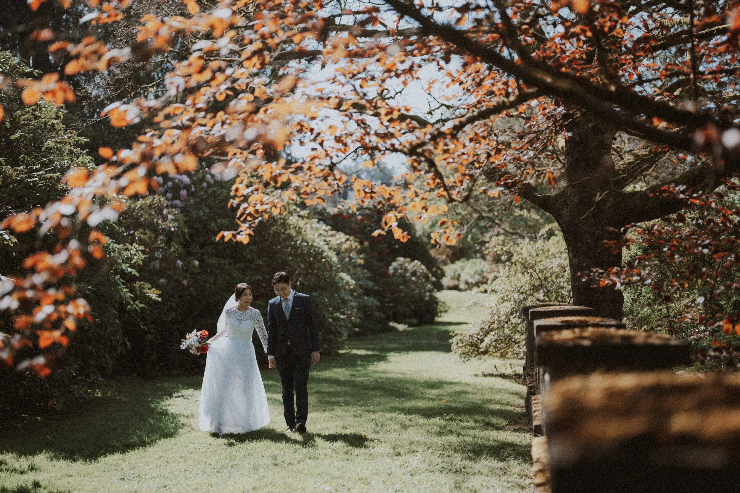  The couple enjoying a romantic walk in the beautiful  Aberthau Mansion garden , with soft sunlight filtering through the trees. 