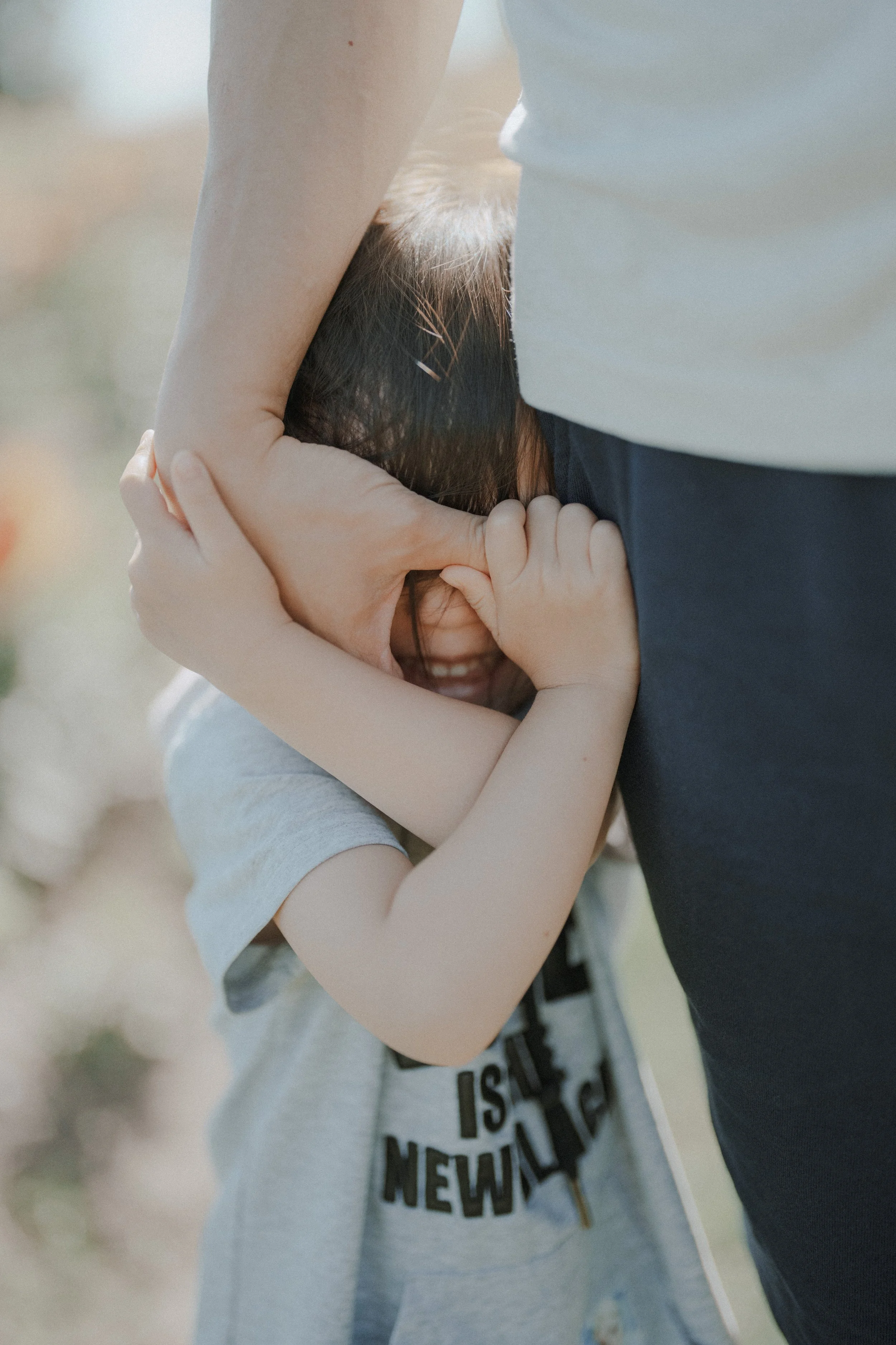Child hugging adult’s arm outdoors at Richmond Country Farms