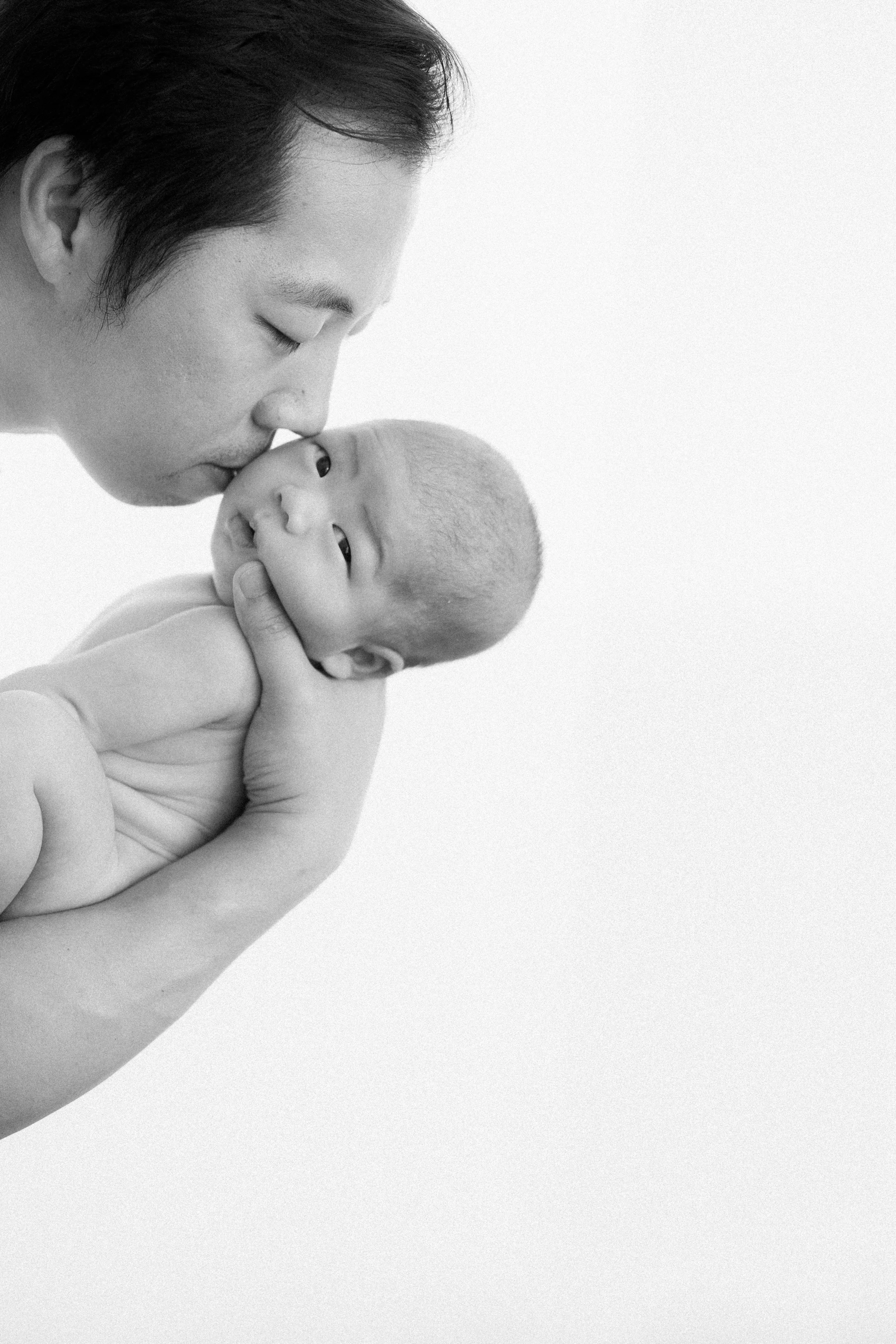  Baby Apollo looks straight at the camera while his father gently kisses his head. 