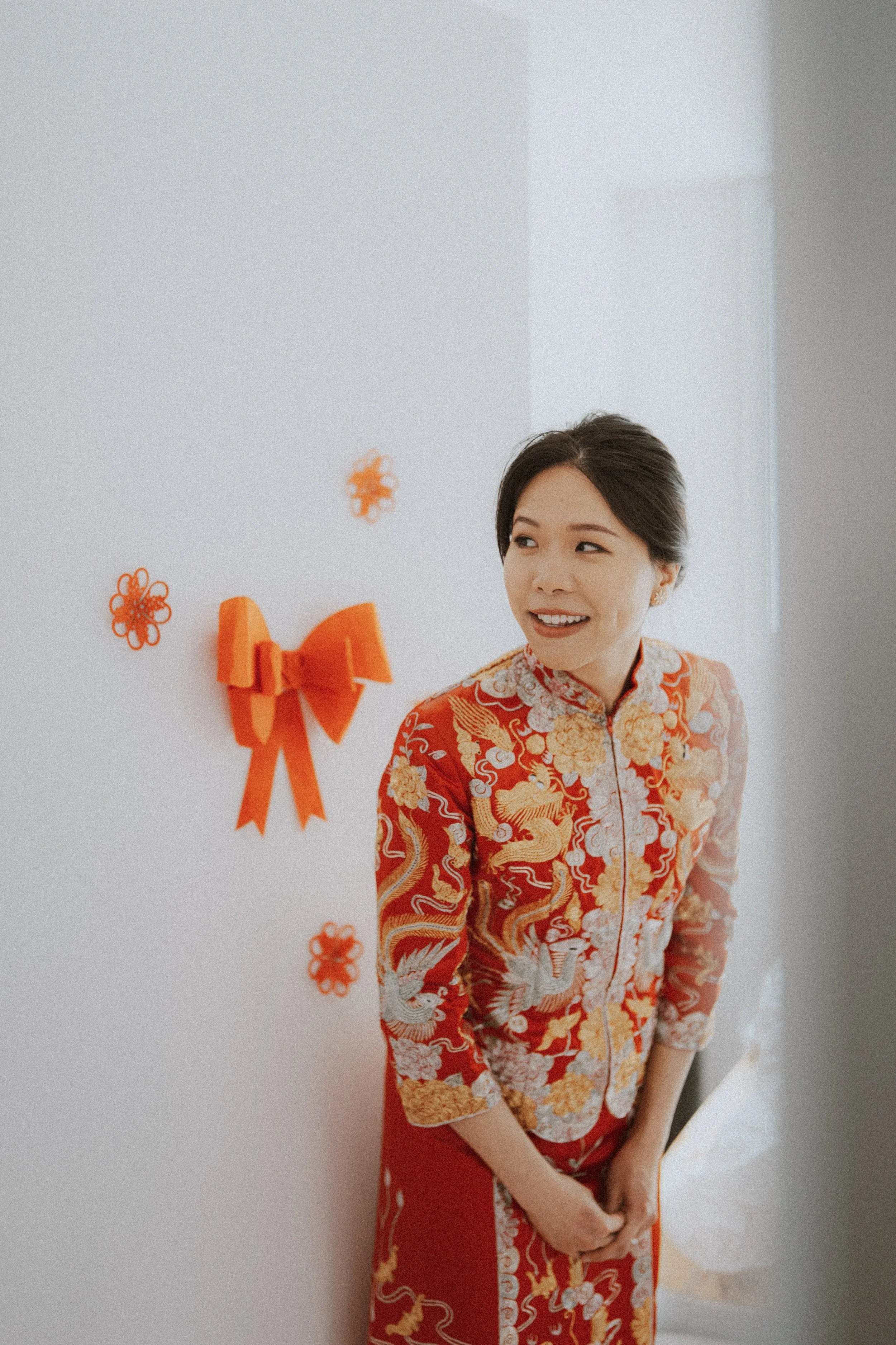  A beautiful, expectant smile from the bride in her vibrant  Qun Gua  dress. Capturing the quiet anticipation before the groom arrives for the  fetching the bride  ritual. 