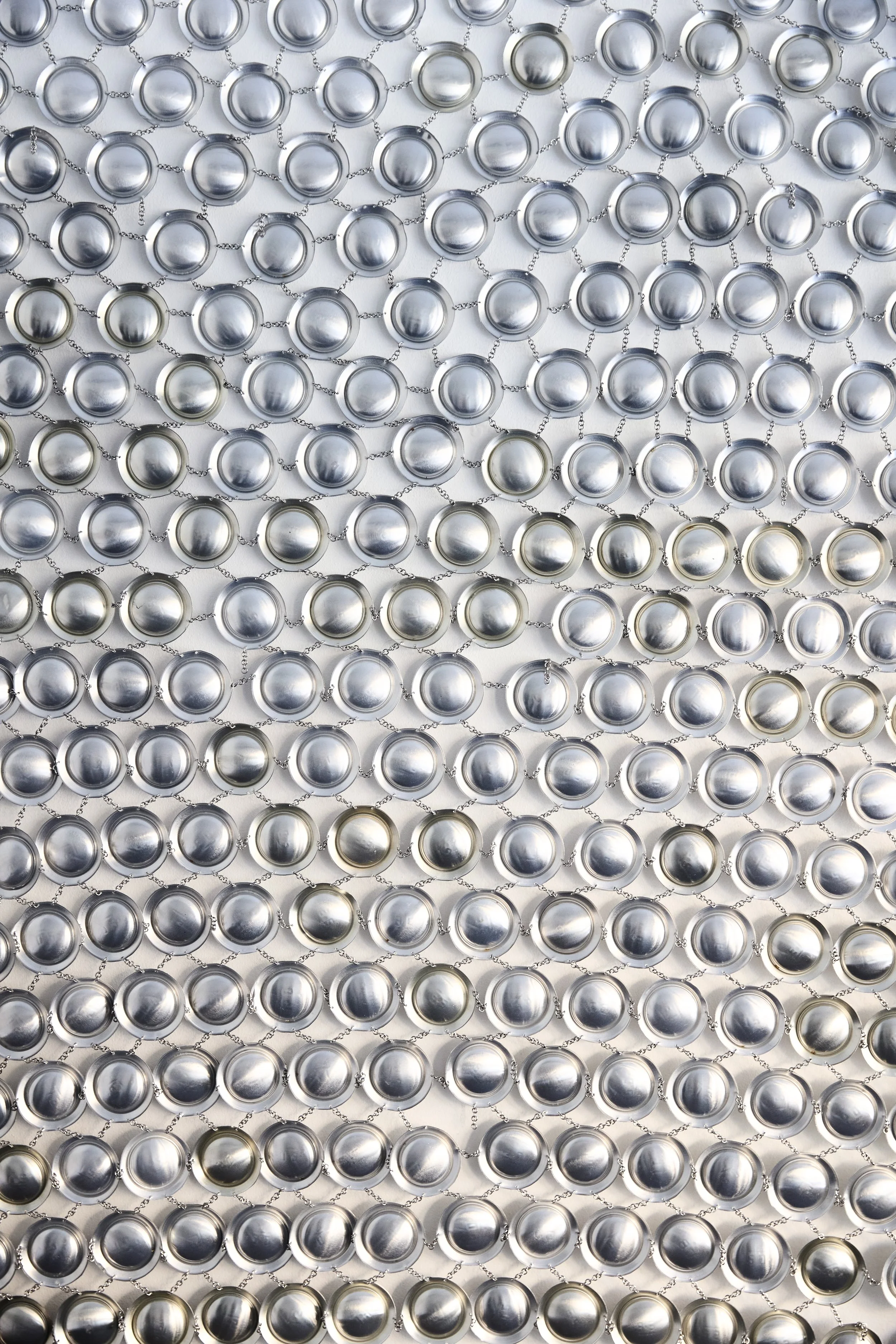OBSESSIVE CONSUMPTION I   
Artist consumed aluminum can bottom, hand linked by o rings
