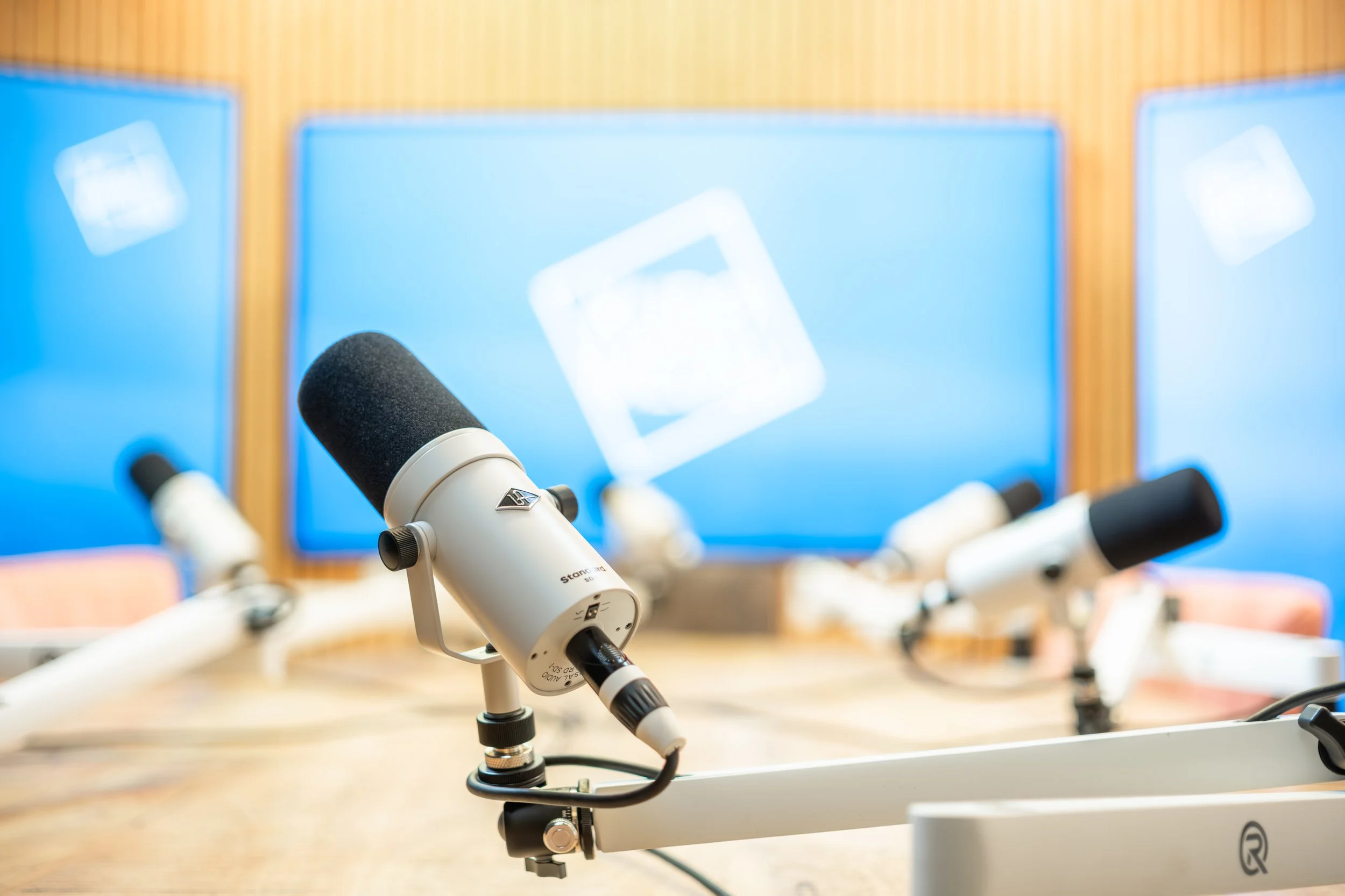 Close-up Foto van de studio bij Kudo Media in Groningen. Setup met Vijf microfoons op de tafel in de podcast studio