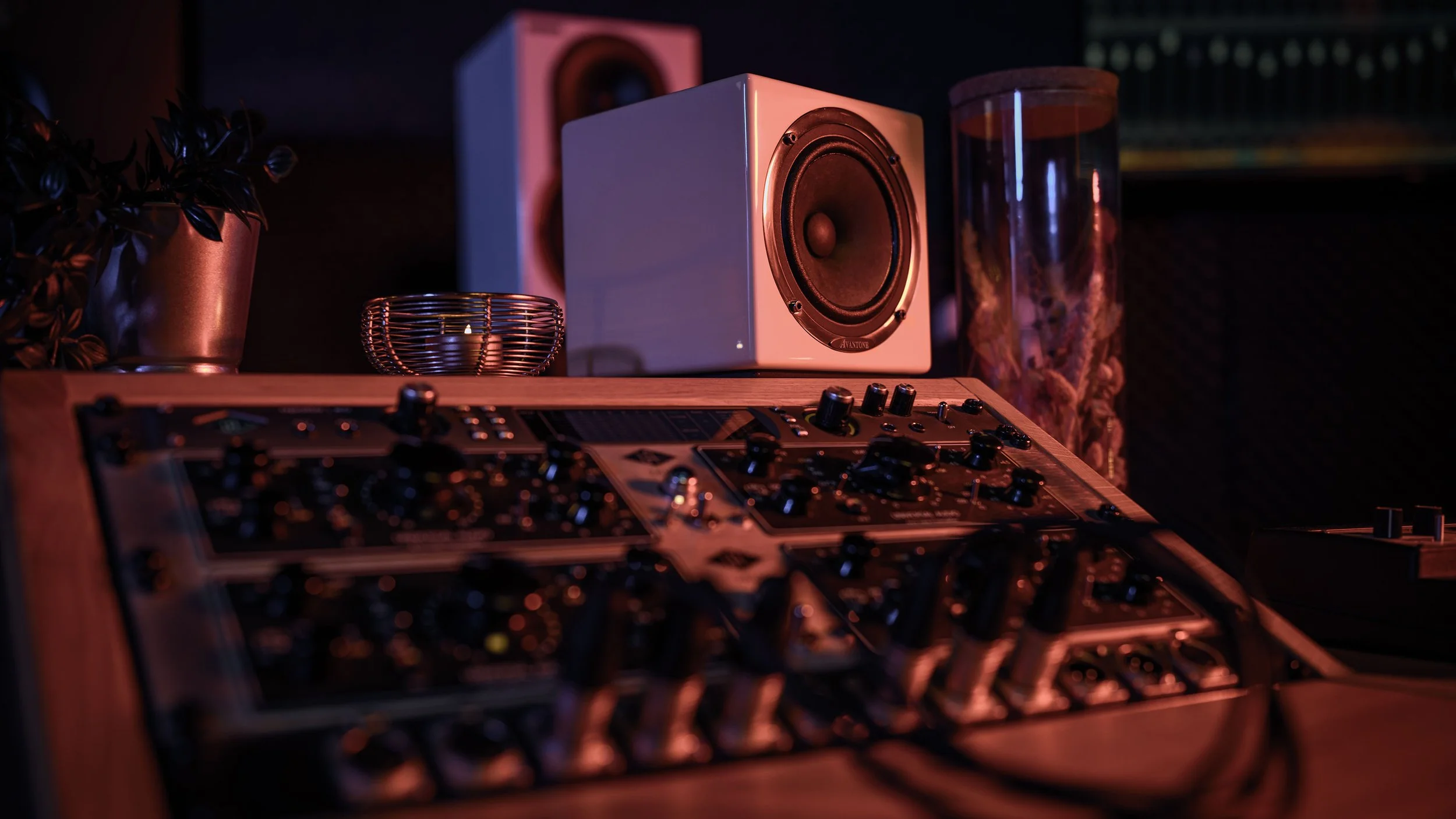 Muziekinstallatie met mengpaneel, luidsprekers, en decoratieve elementen in een opnamestudio.