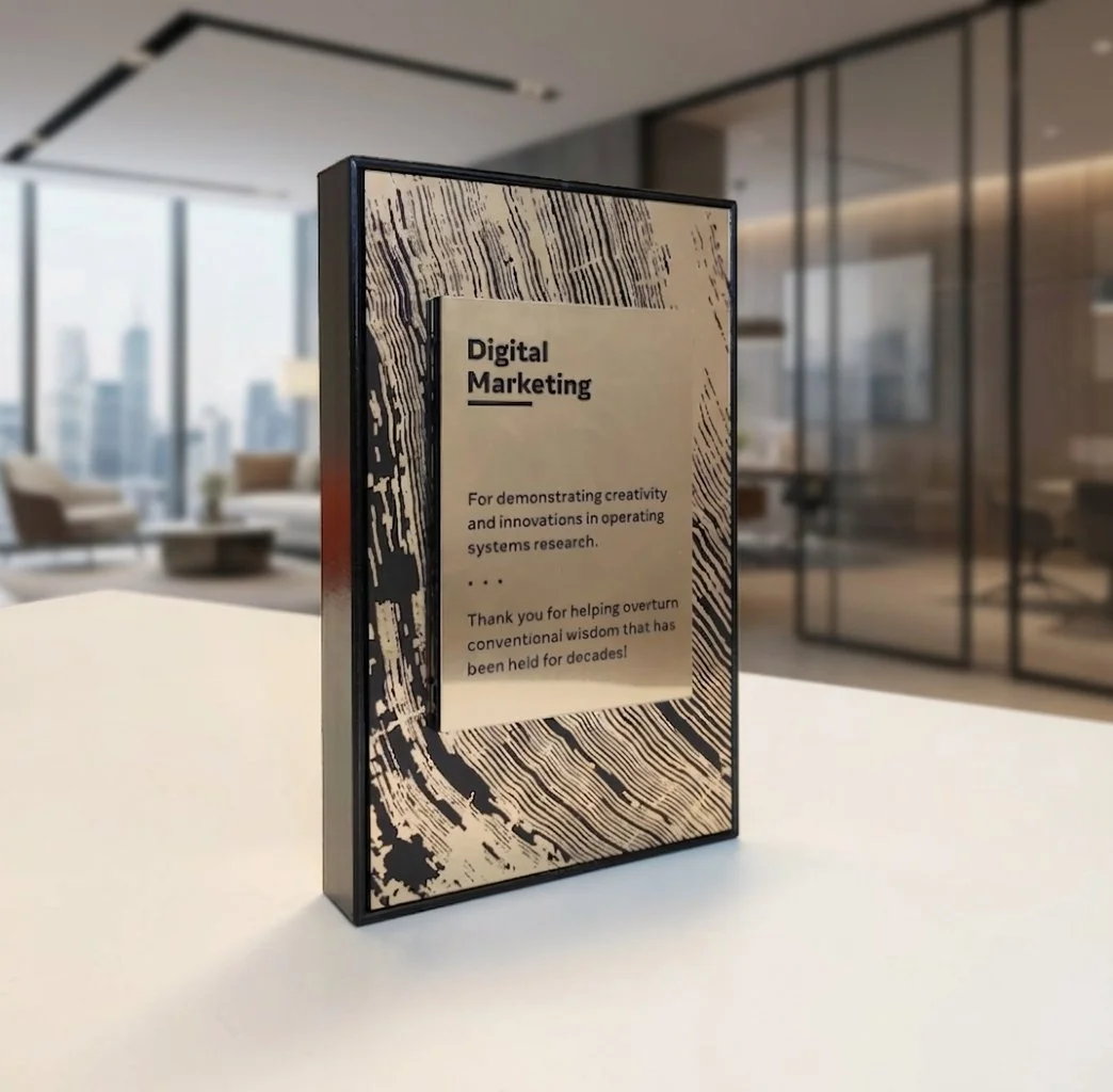 Framed recognition award with printed message and black border displayed on a tabletop in an office setting