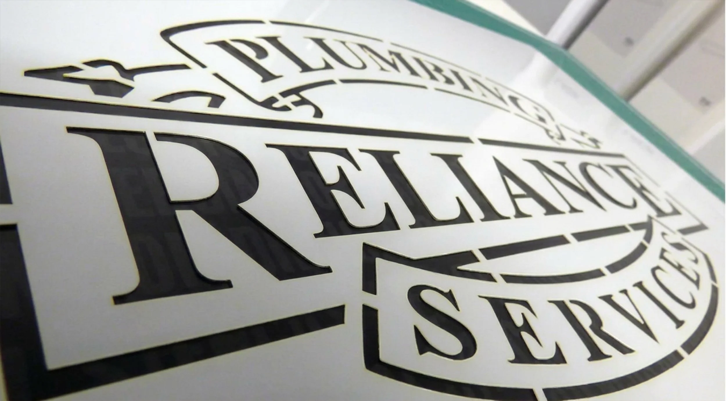 Close-up of a decal with black text on a white background reading 'PRELANCE' and part of a circular logo design.