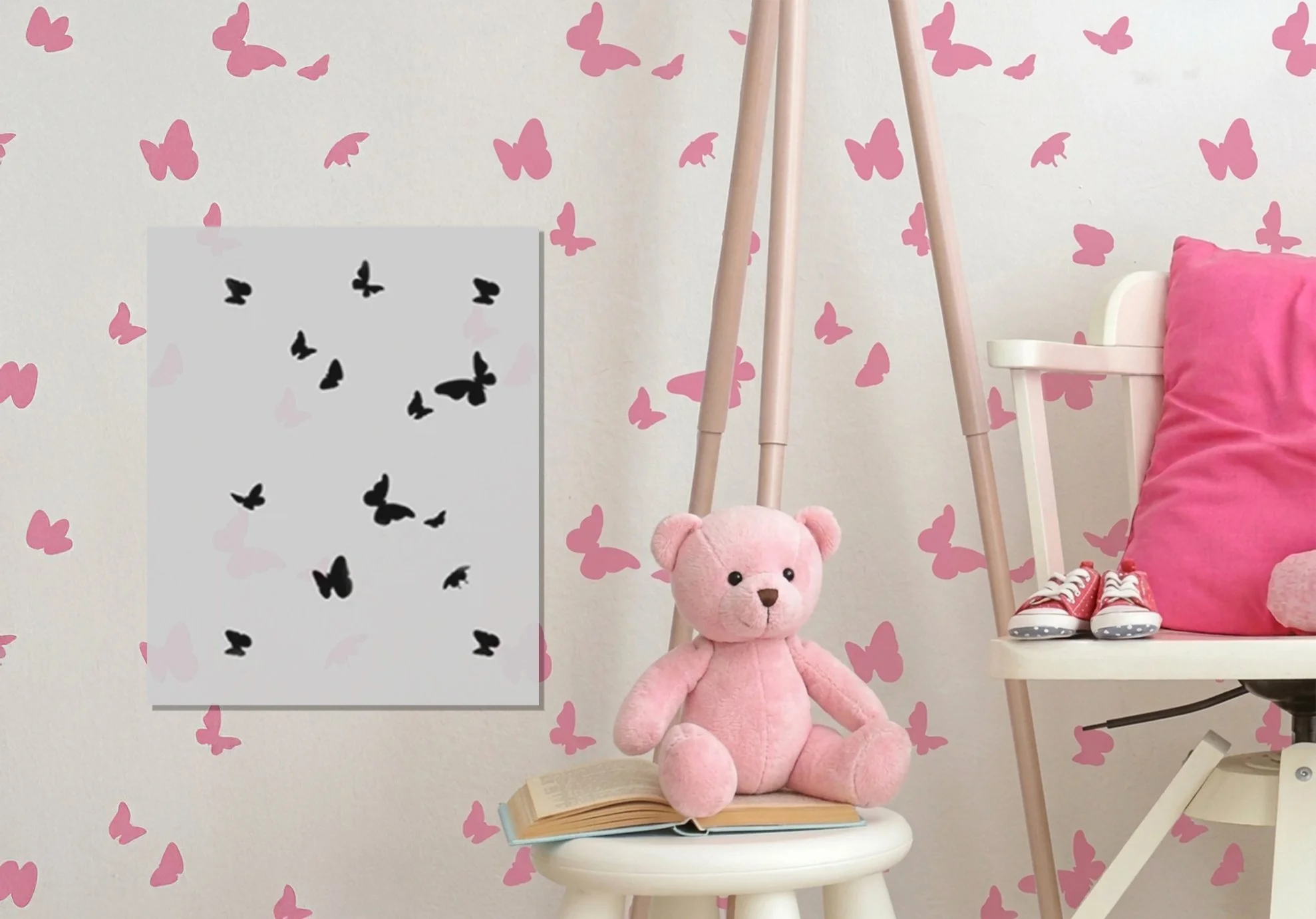 A pink teddy bear sitting on an open book on a white stool in a room with pink butterfly wall decals, next to a white chair with a pink pillow and red sneakers, and pink butterfly wall decals in the background.