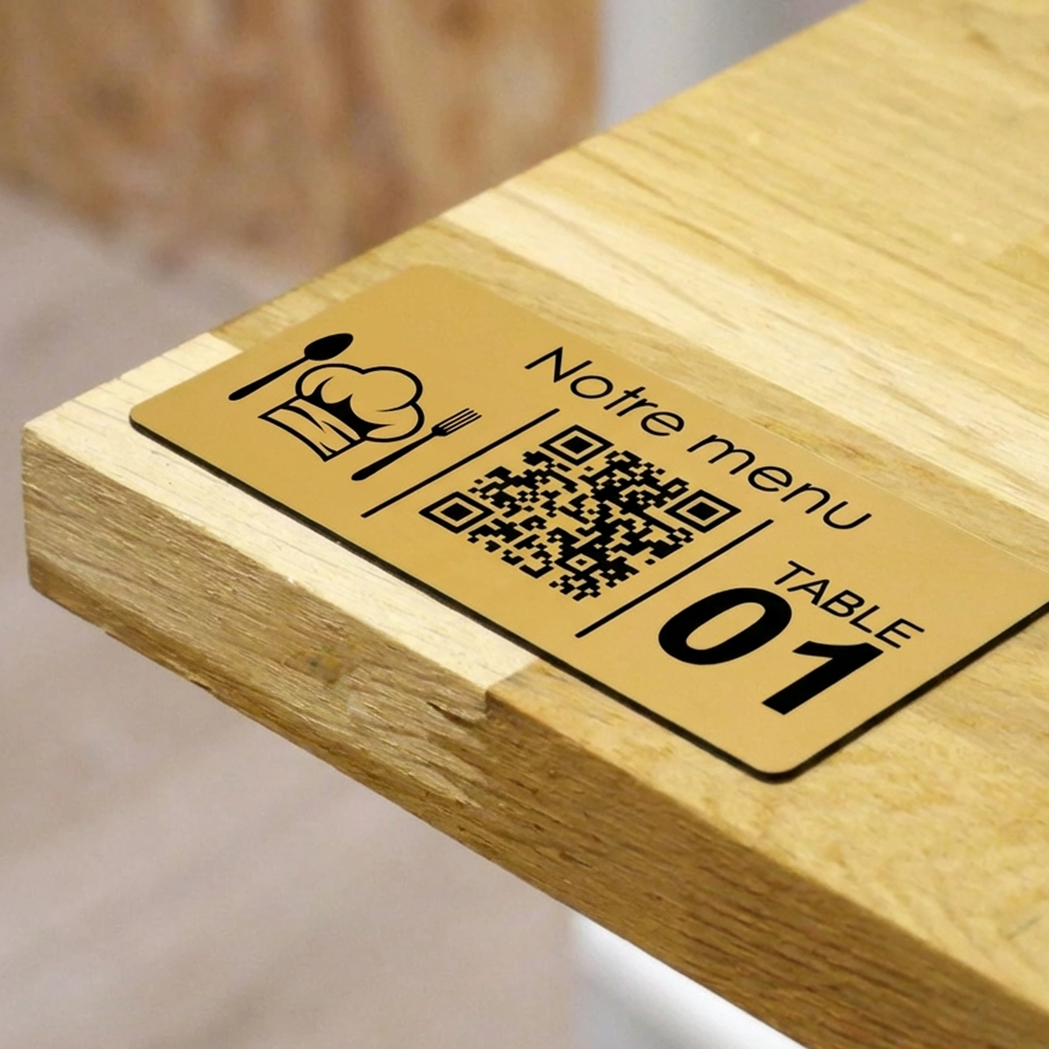 Metal-look tabletop QR code marker with menu icon and table number displayed on a wooden table edge