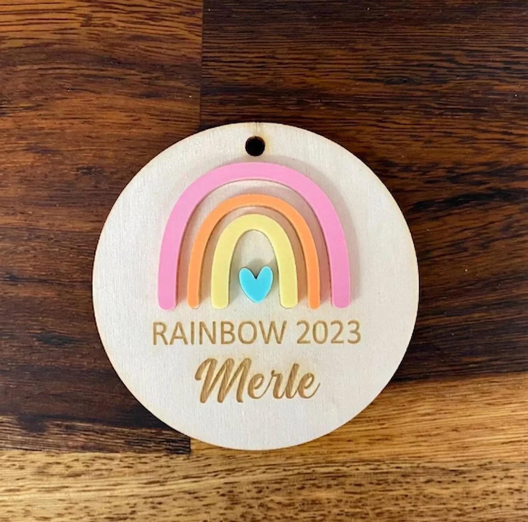 Personalised wooden name plaque with layered acrylic rainbow design and engraved text, suitable for nursery or children’s room decor