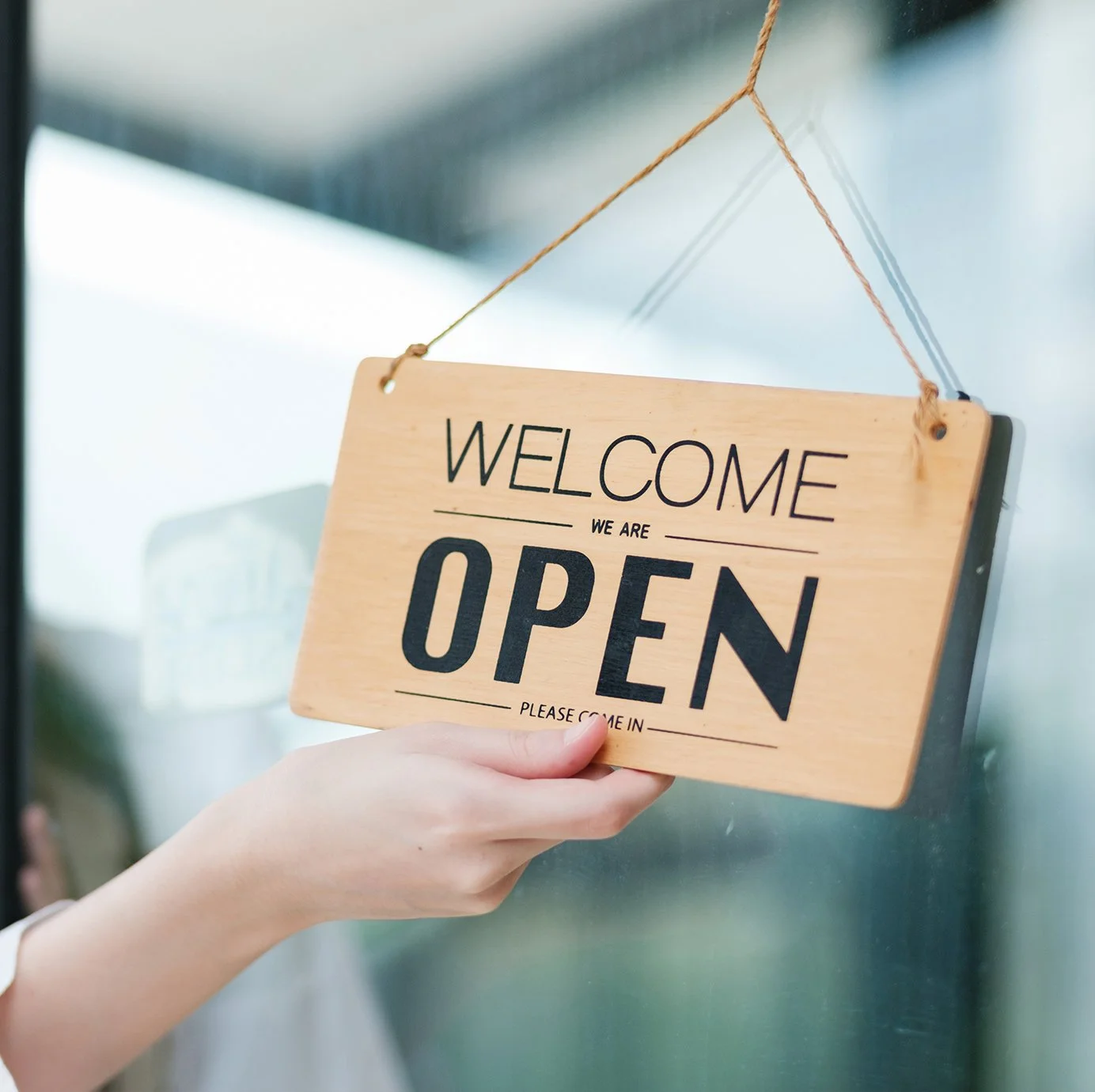 Stencil-style lettering design shown on a wooden welcome sign for retail or display use