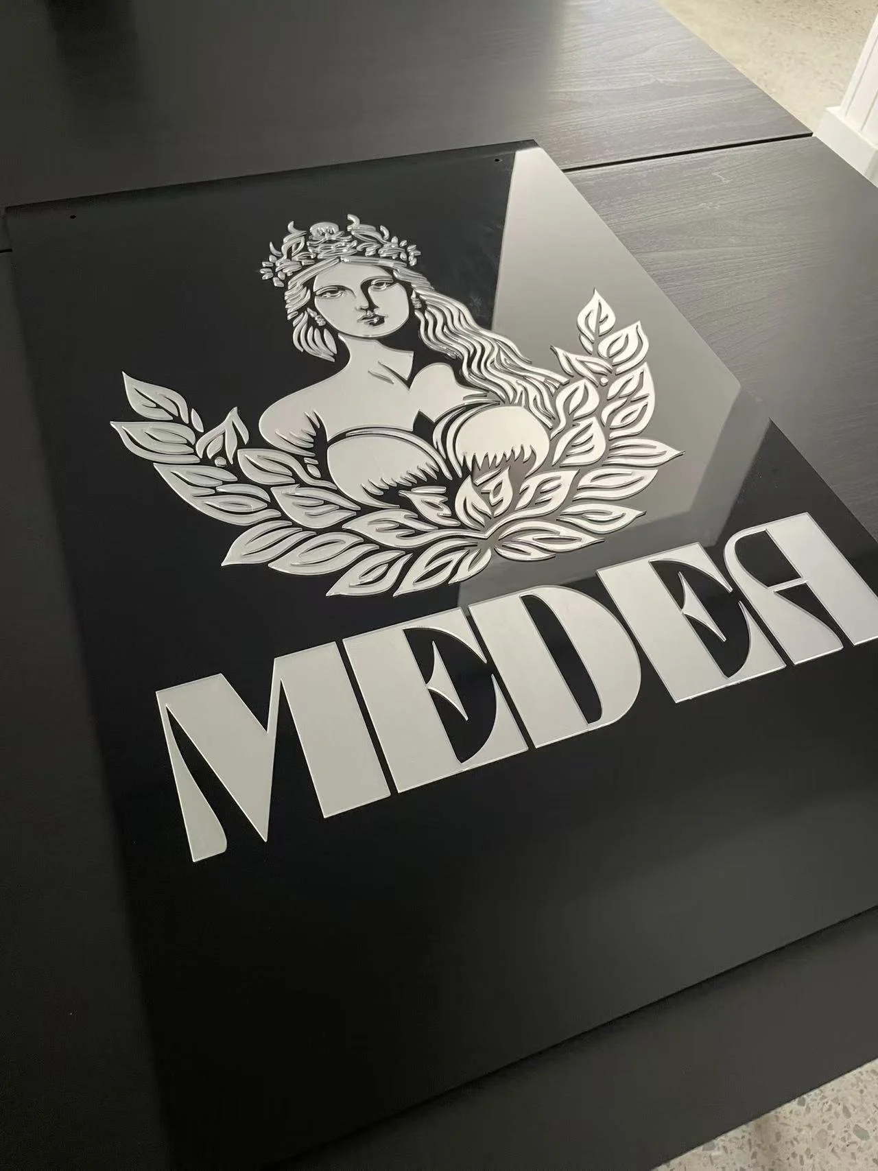 Premium 3D acrylic shop signage with layered logo artwork and bold raised lettering in a modern black-and-white finish.